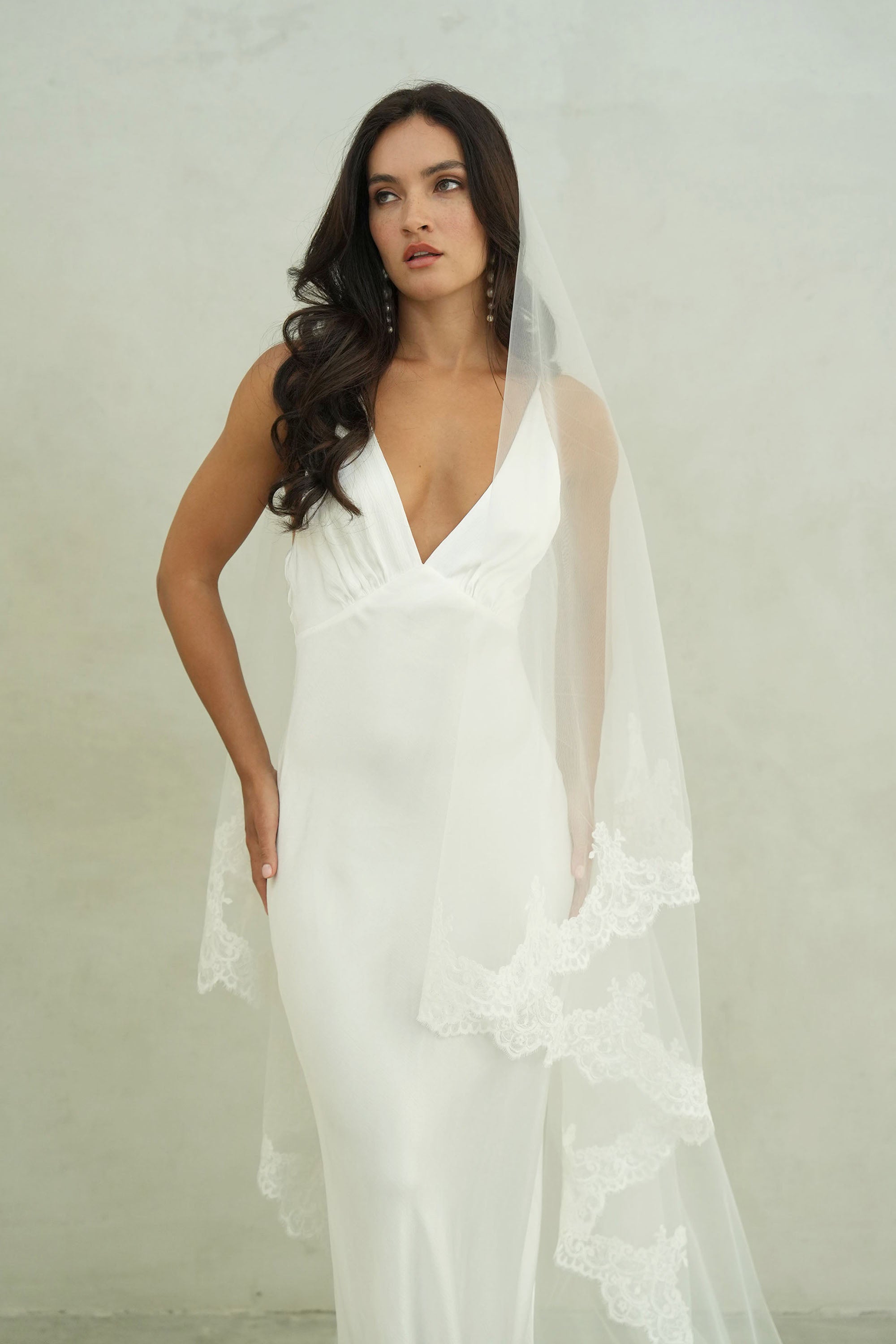 model wears a mantilla lace trim veil, drop lace edged wedding veil