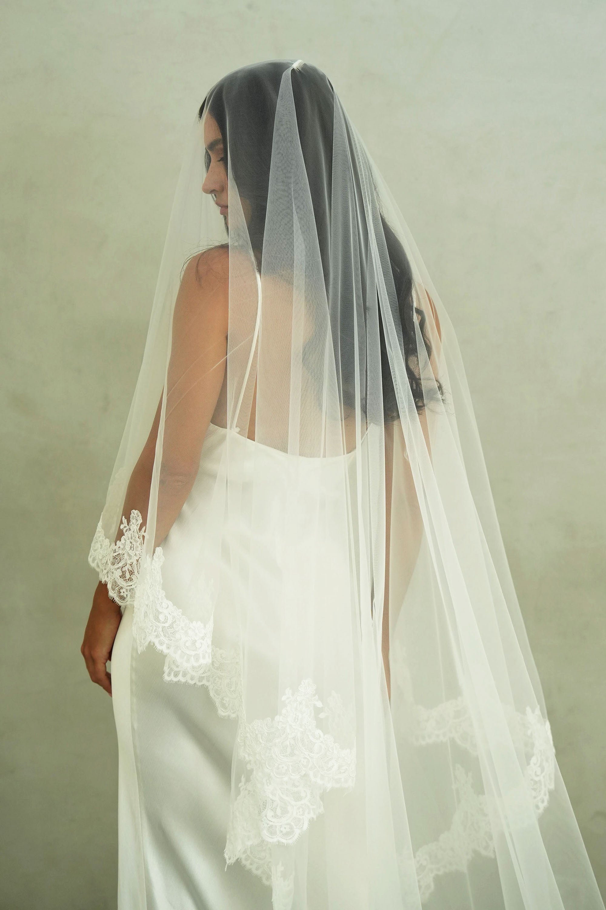 model wears a mantilla lace trim veil, drop lace edged wedding veil