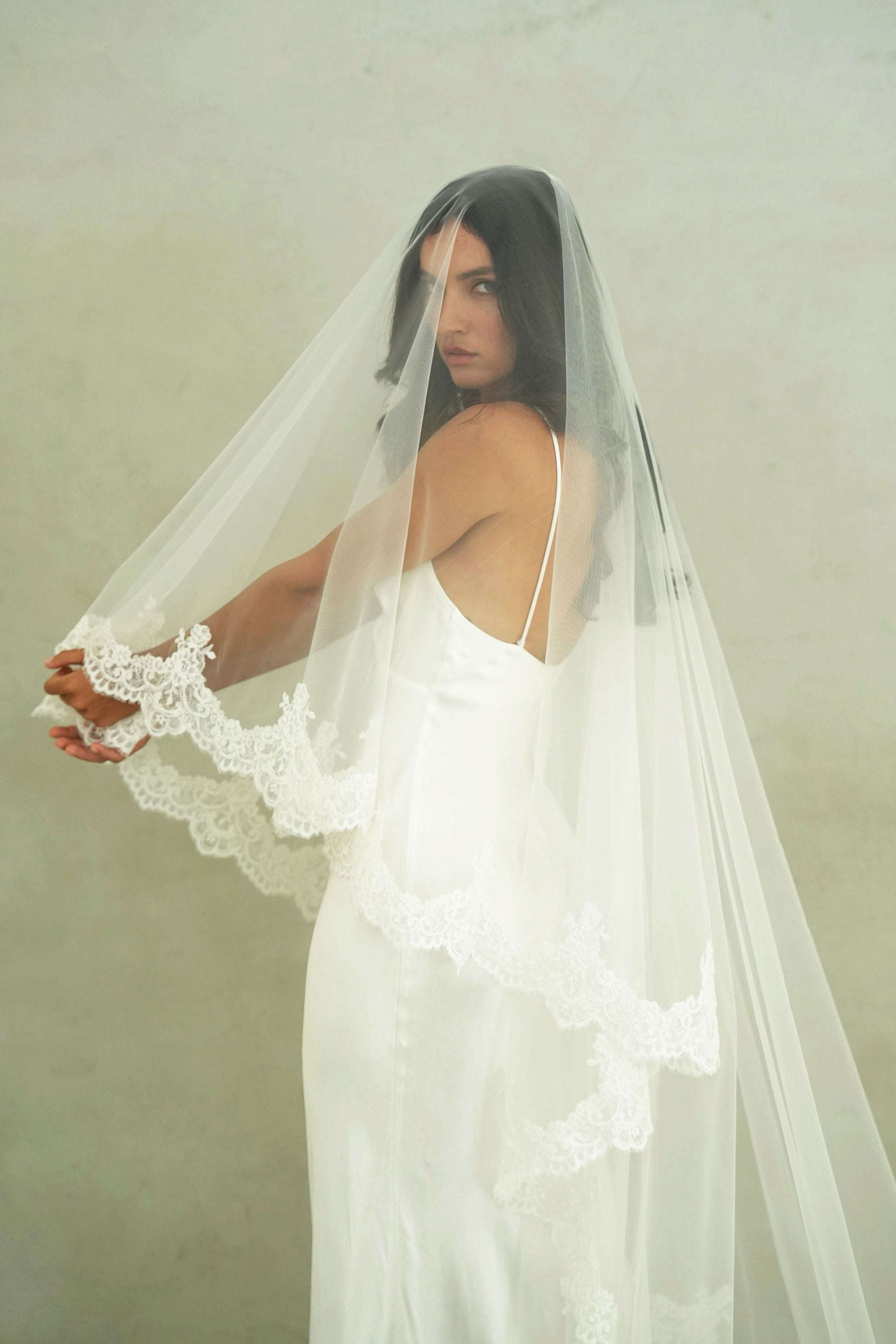 model wears a mantilla lace trim veil, drop lace edged wedding veil