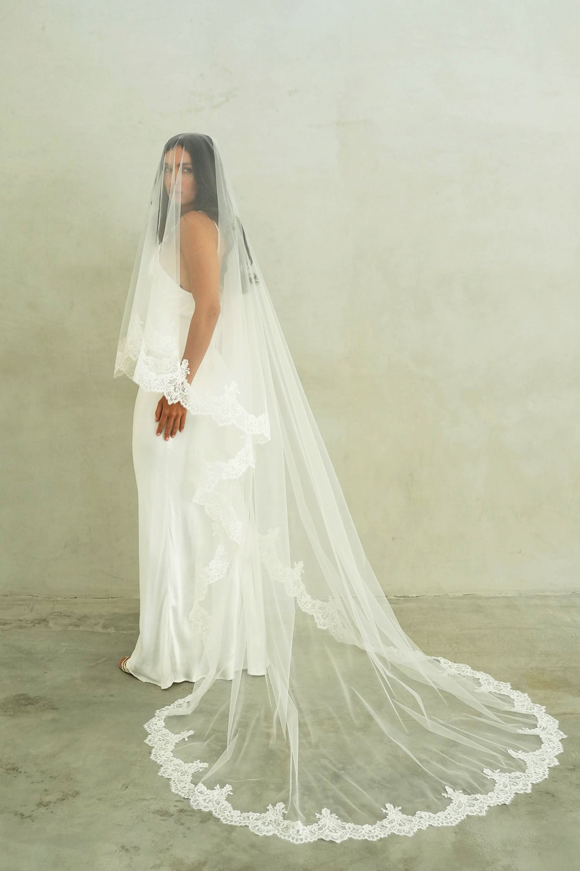 model wears a mantilla lace trim veil, drop lace edged wedding veil