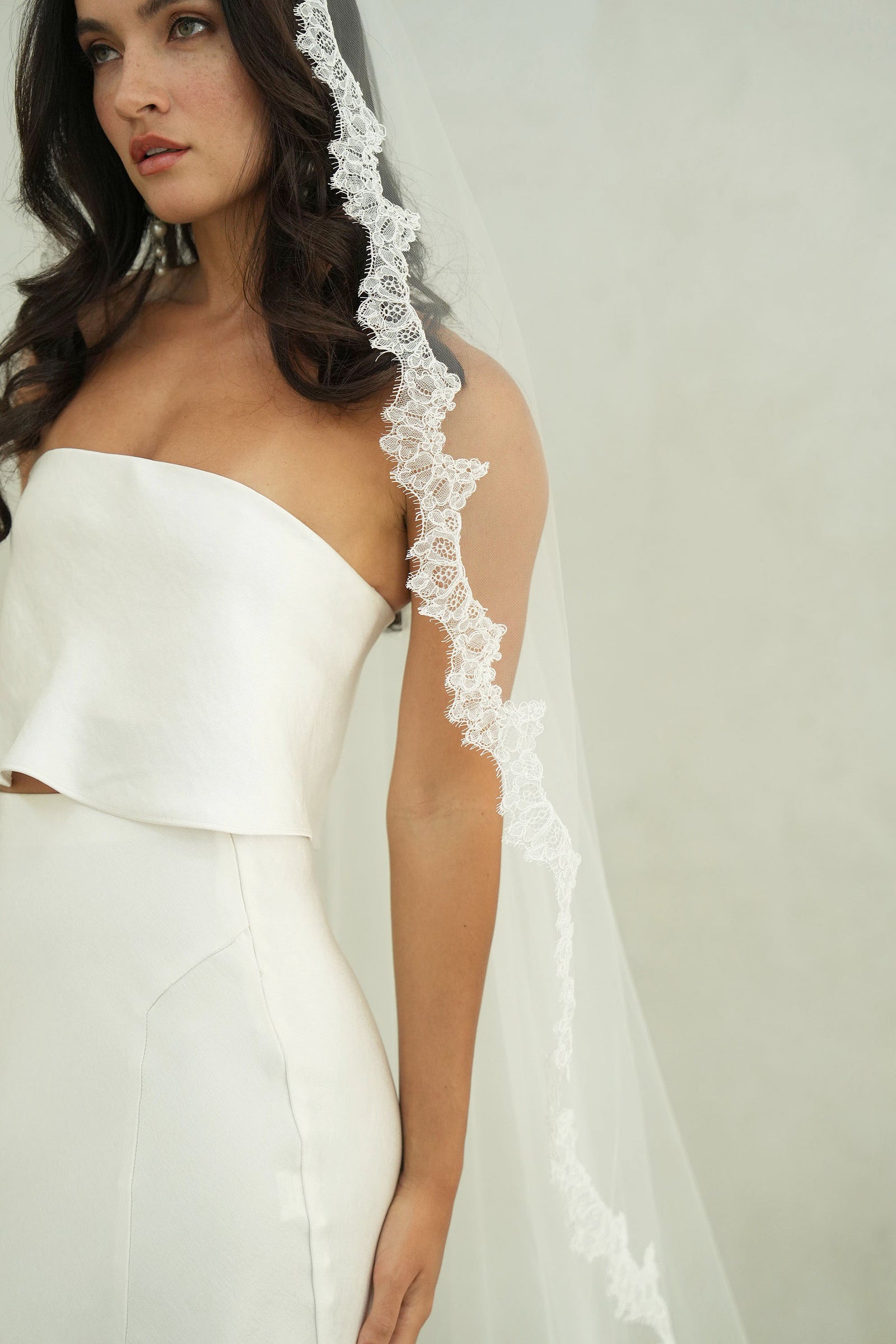 model wears mantilla veil, single-tier wedding veil with lace trim