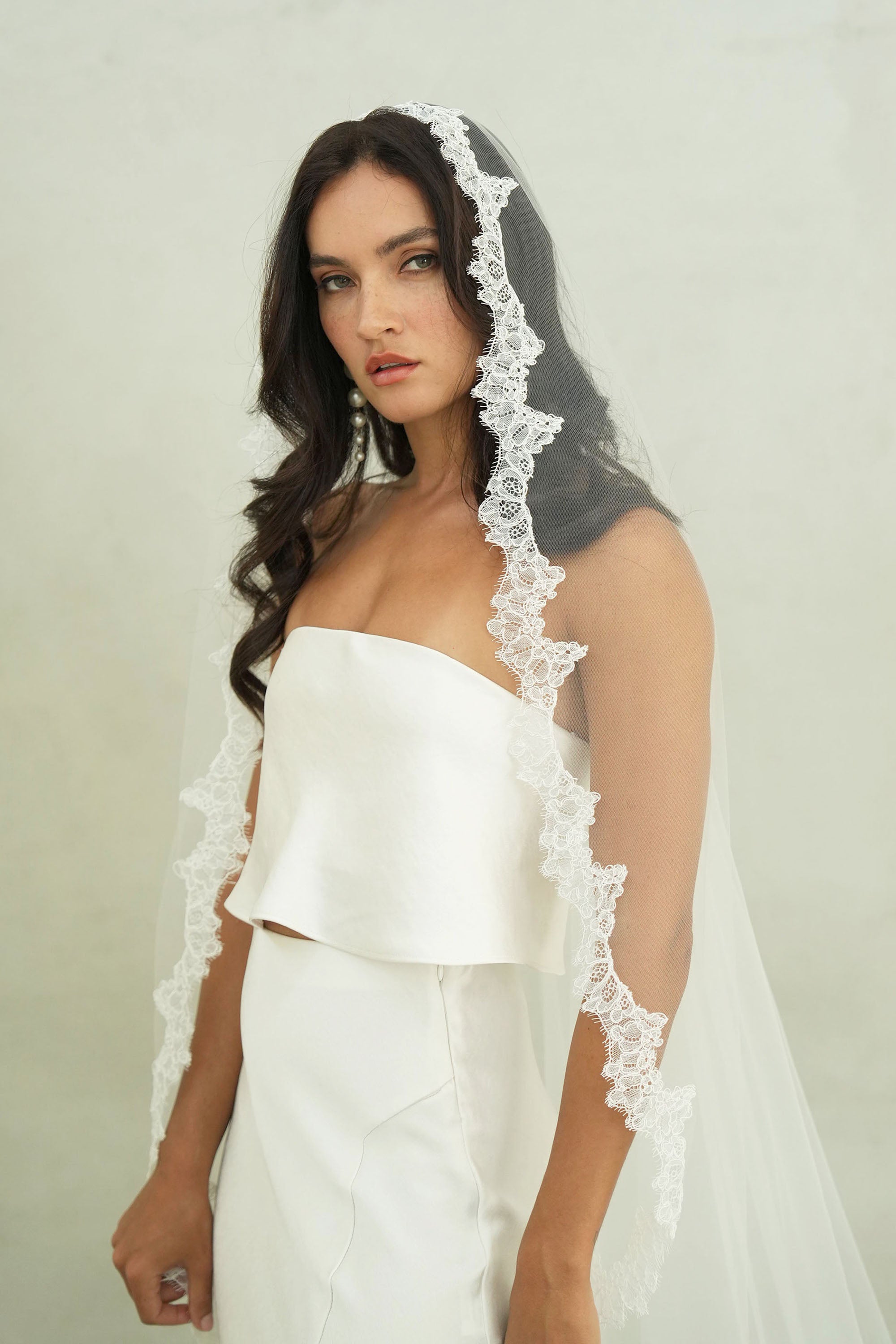 model wears mantilla veil, single-tier wedding veil with lace trim