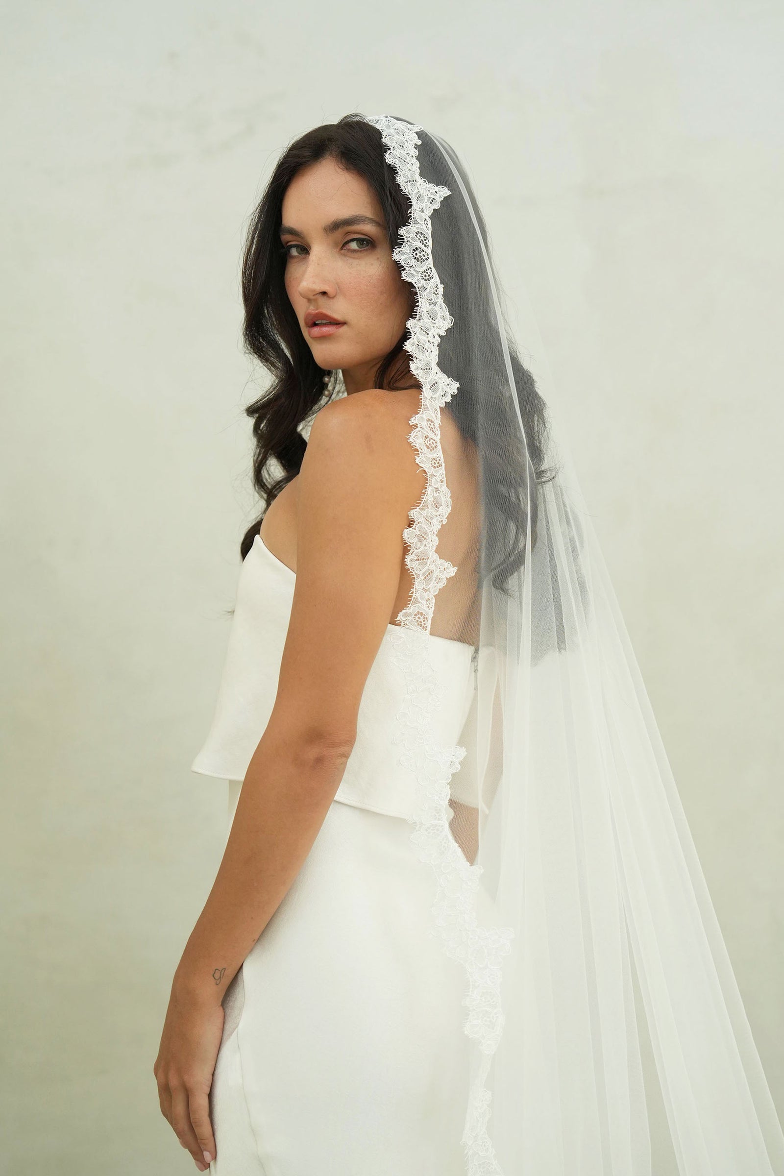 model wears mantilla veil, single-tier wedding veil with lace trim
