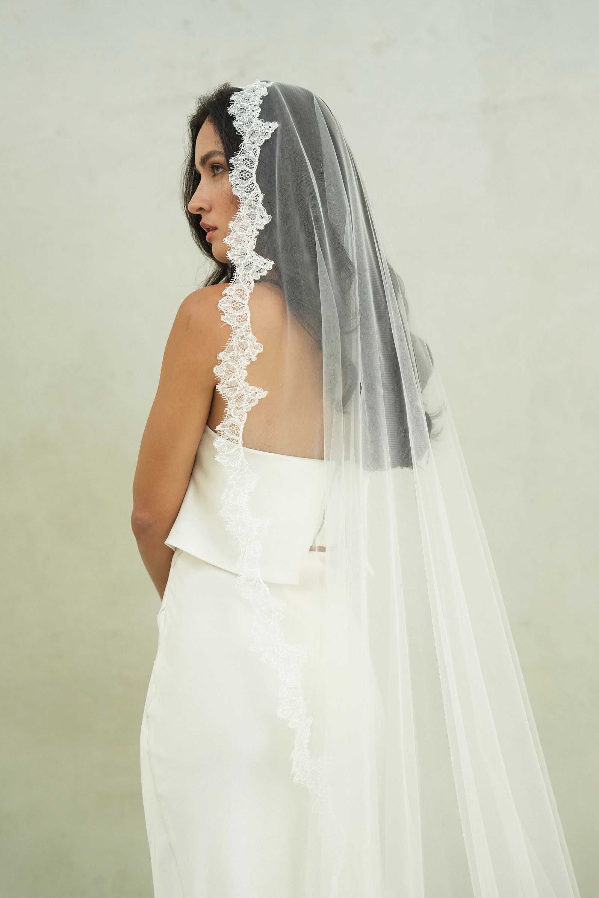 model wears mantilla veil, single-tier wedding veil with lace trim