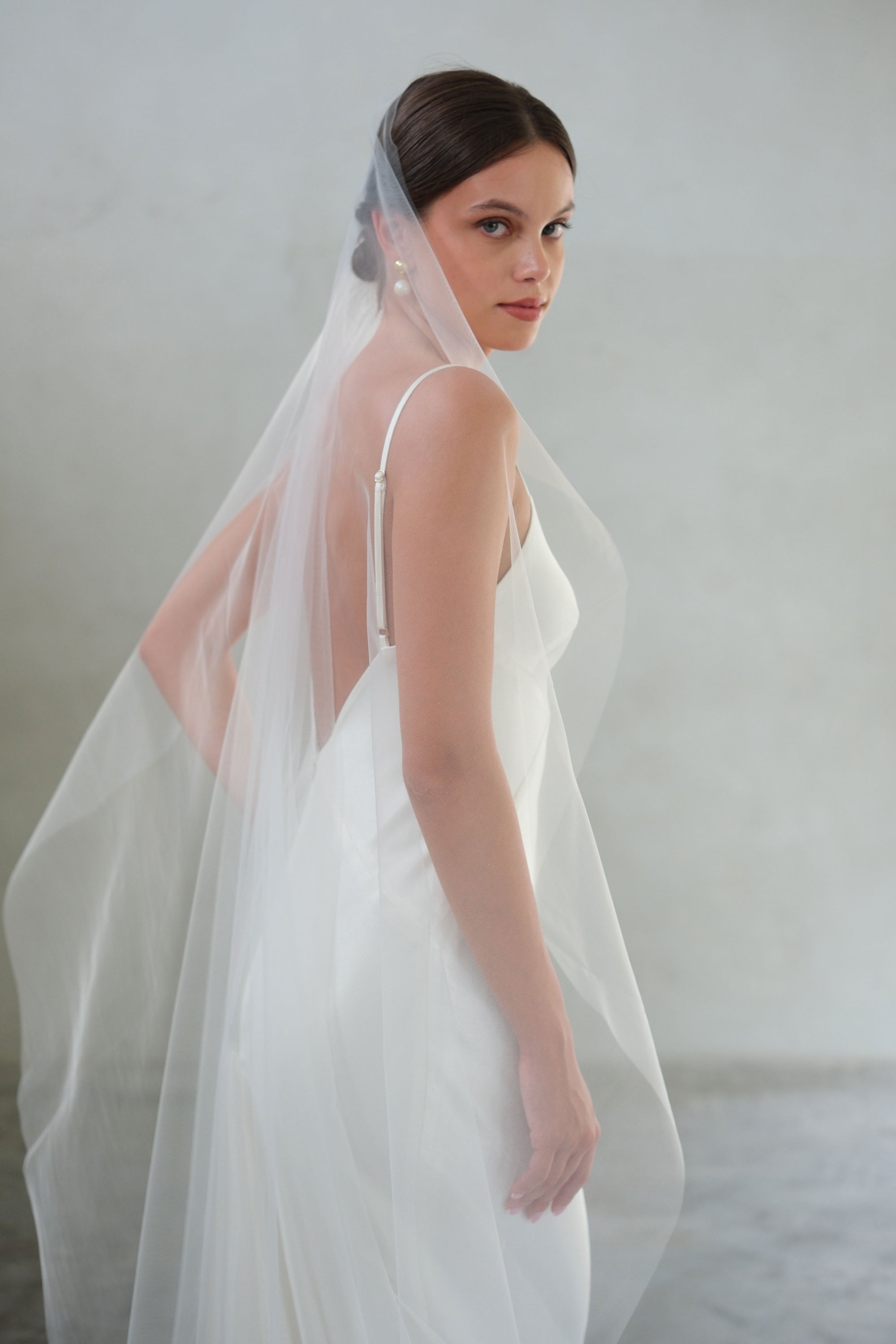 Half length side view of bride wearing one tier plain veil