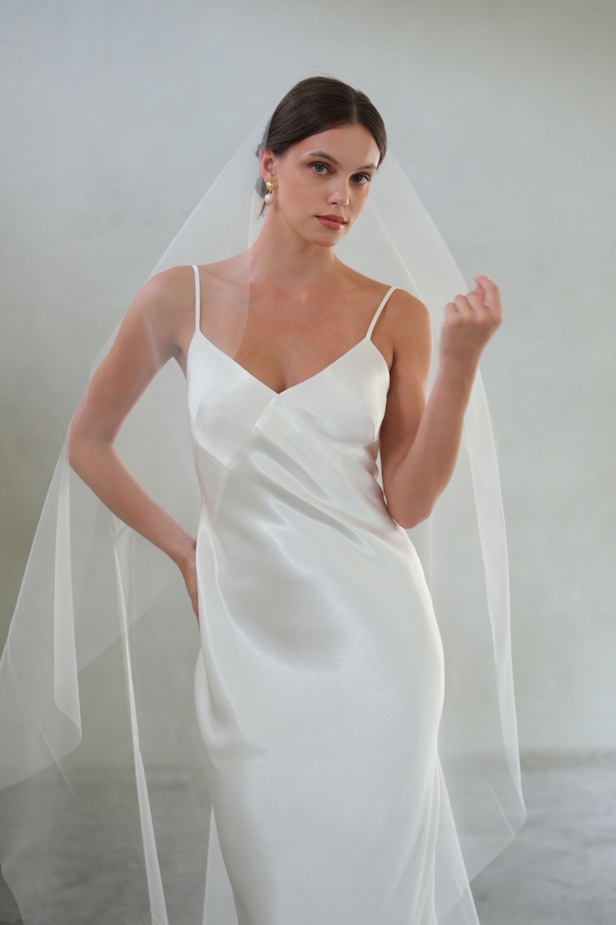 Half length front facing bride wears plain tulle veil