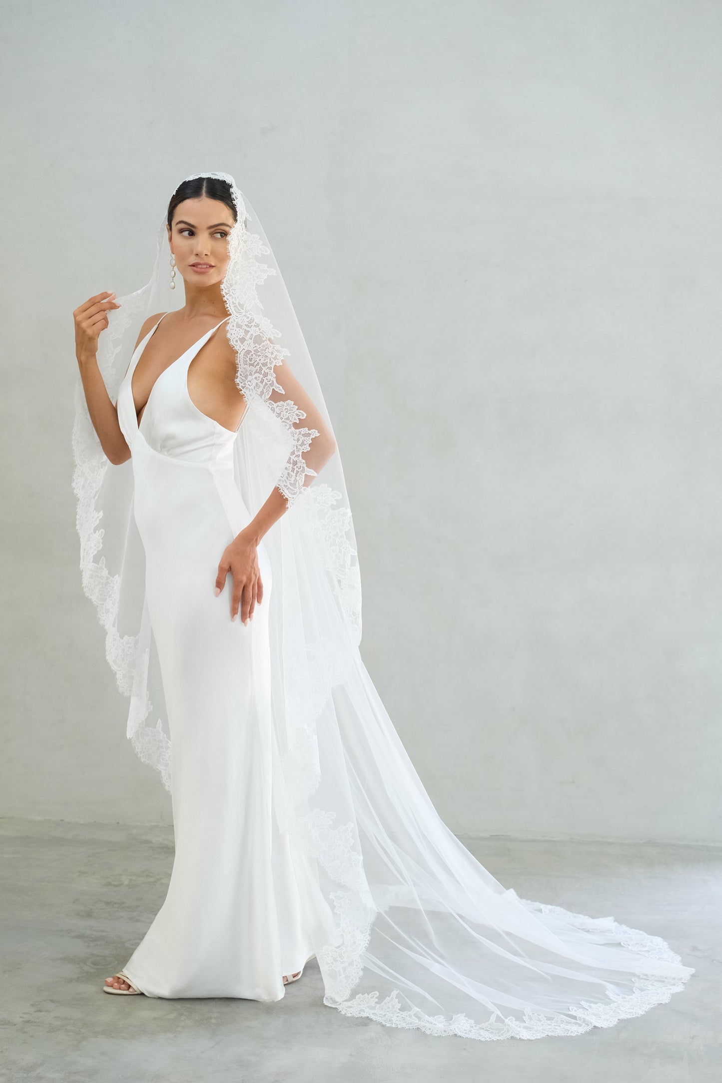 Full length bride models long mantilla wedding veil trimmed with lace
