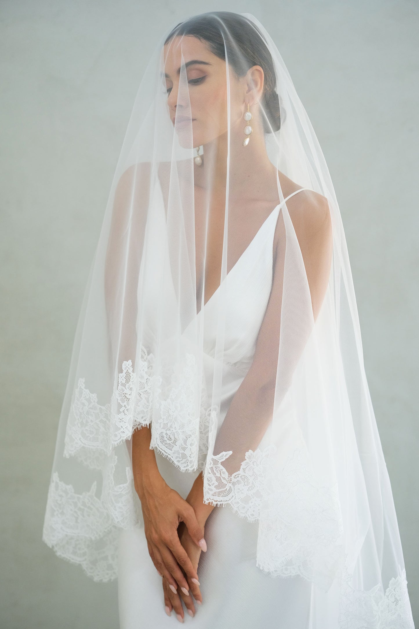 Bride wears blusher down on lace trimmed veil
