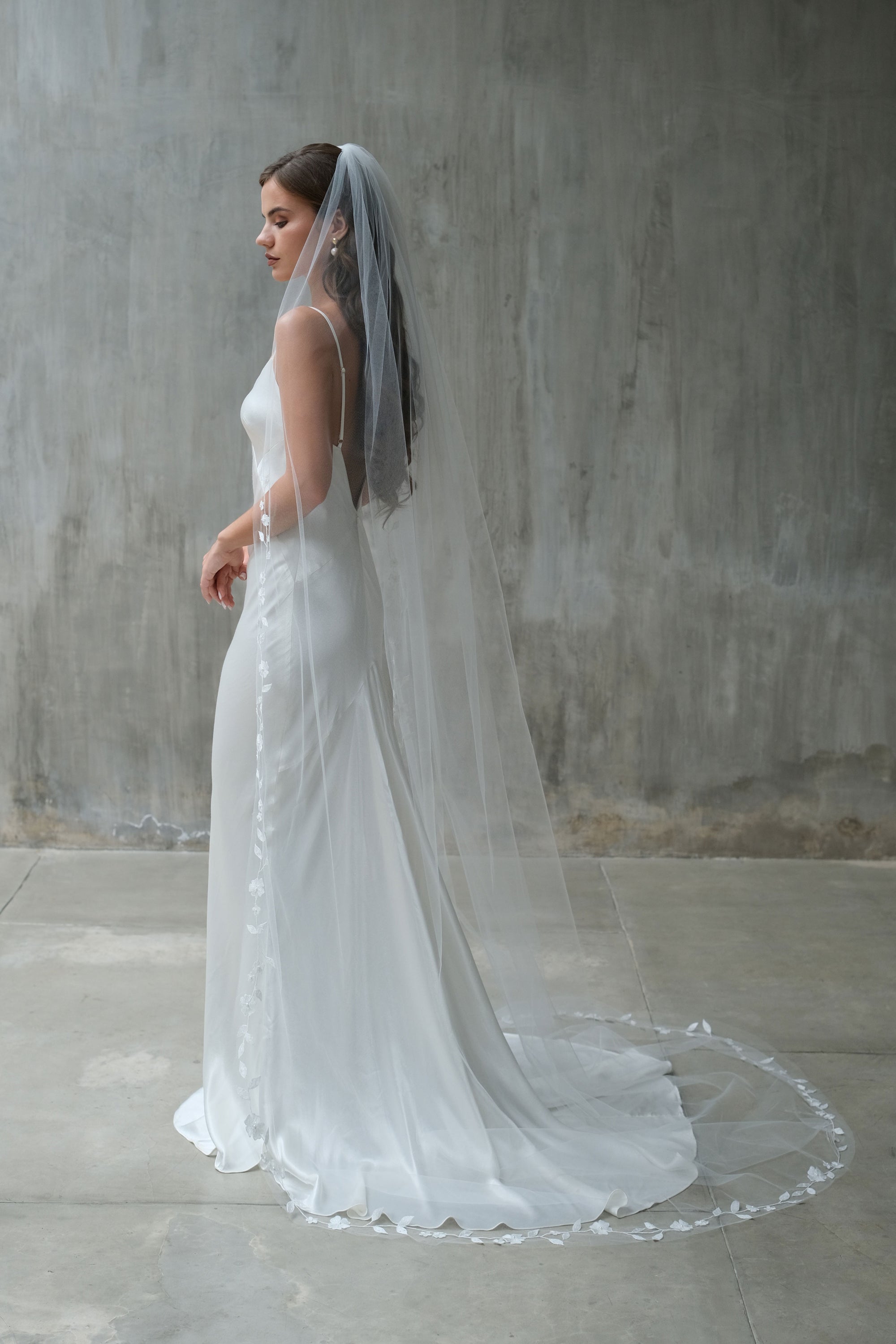 Full length profile showing long, single-tier bridal veil edged with floral embroidery