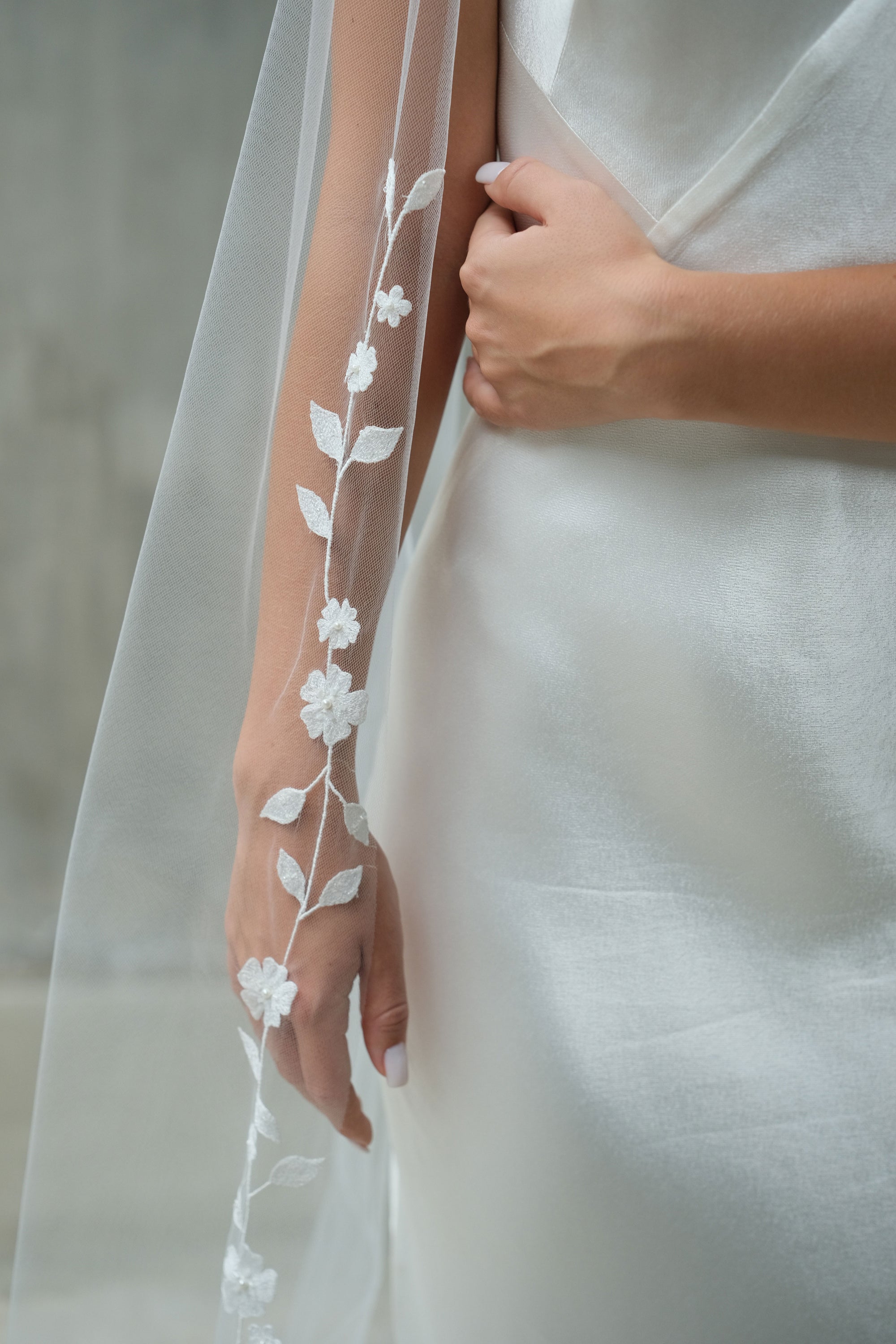Detail of hand-stiched floral embroidery with subtle beading on delicate bridal veil