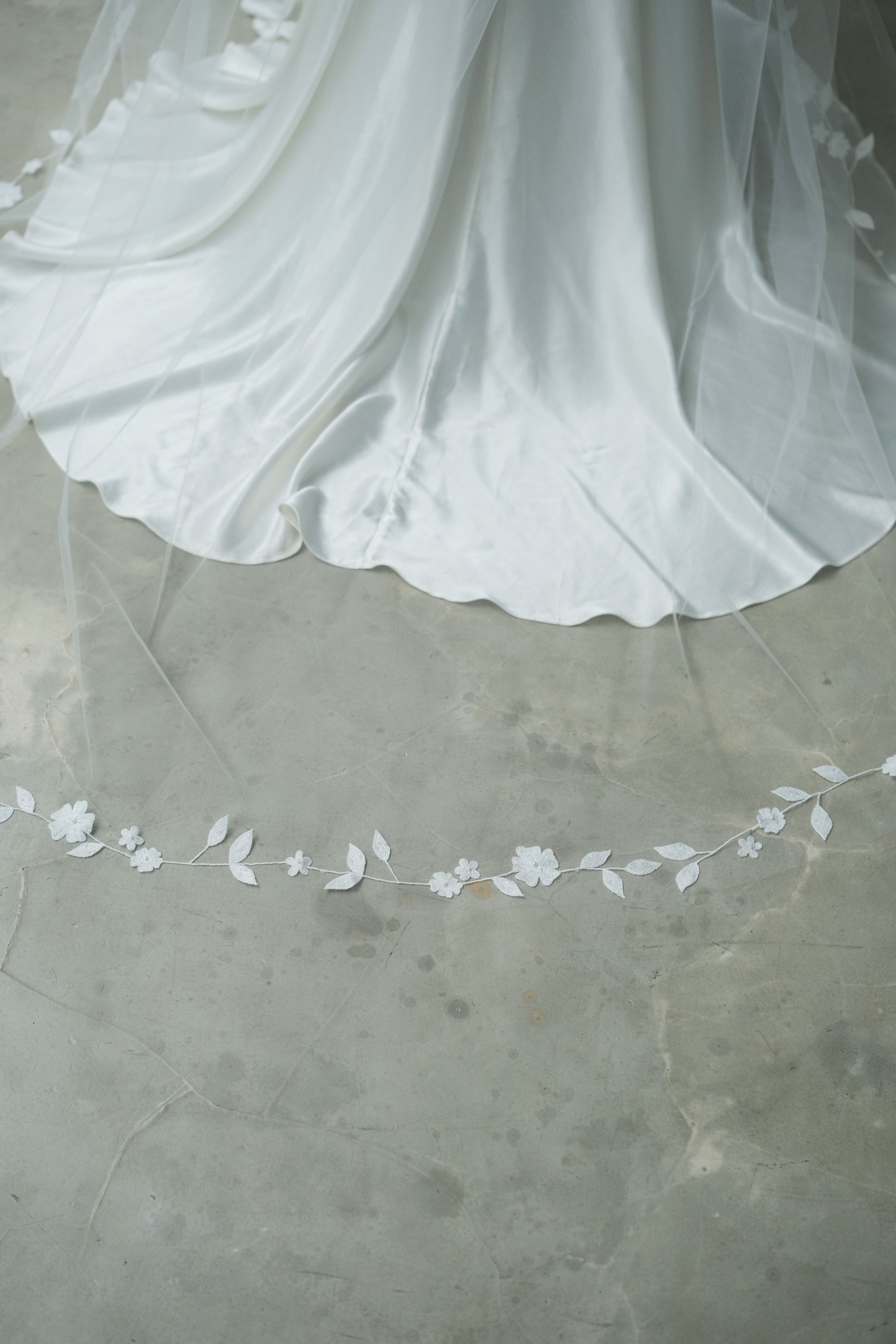 Delicate floral vine-style embroidery detail edging the train of long bridal veil