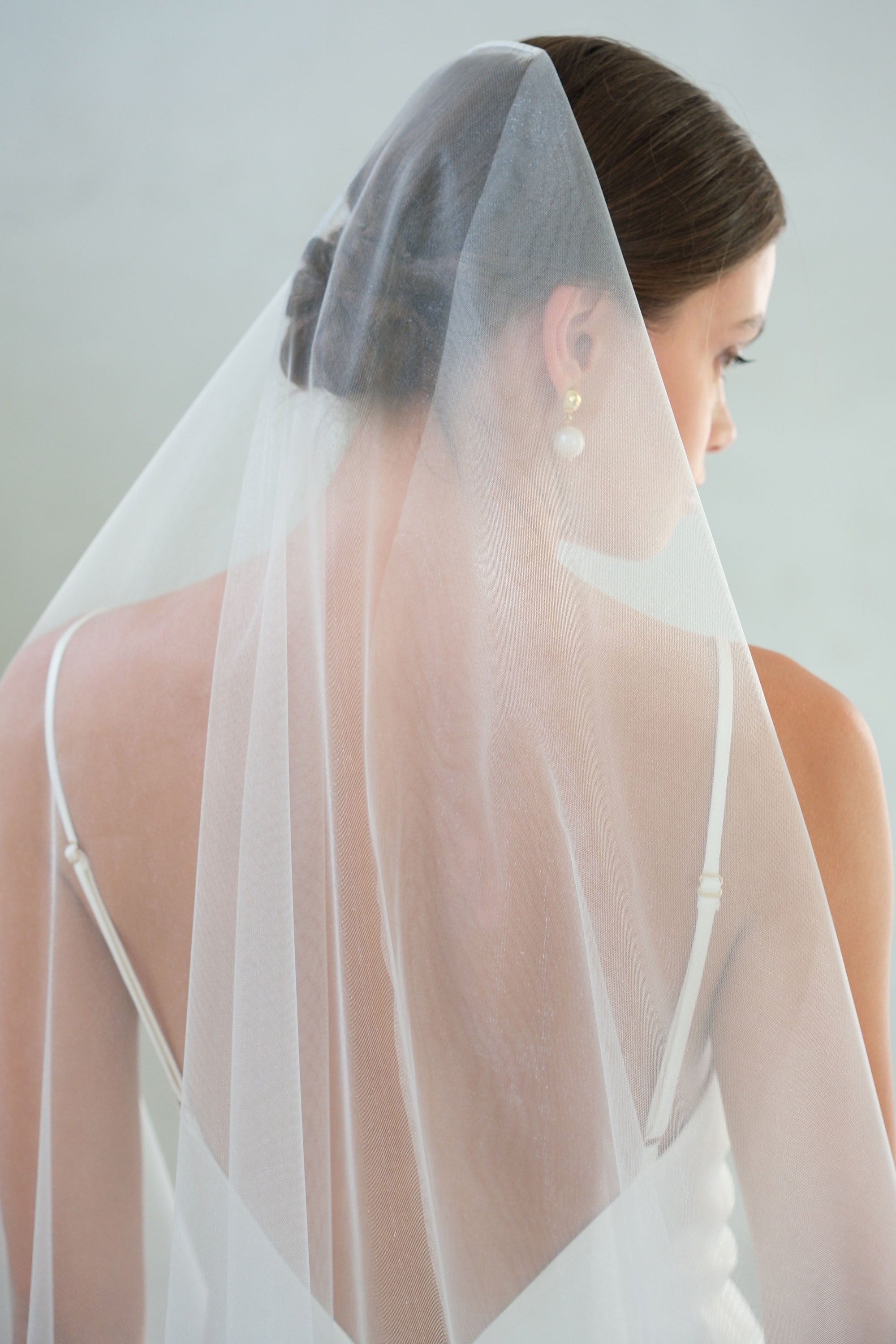 Back view, head &amp; shoulders of bride wearling plain, mantilla style veil - shimmer tulle