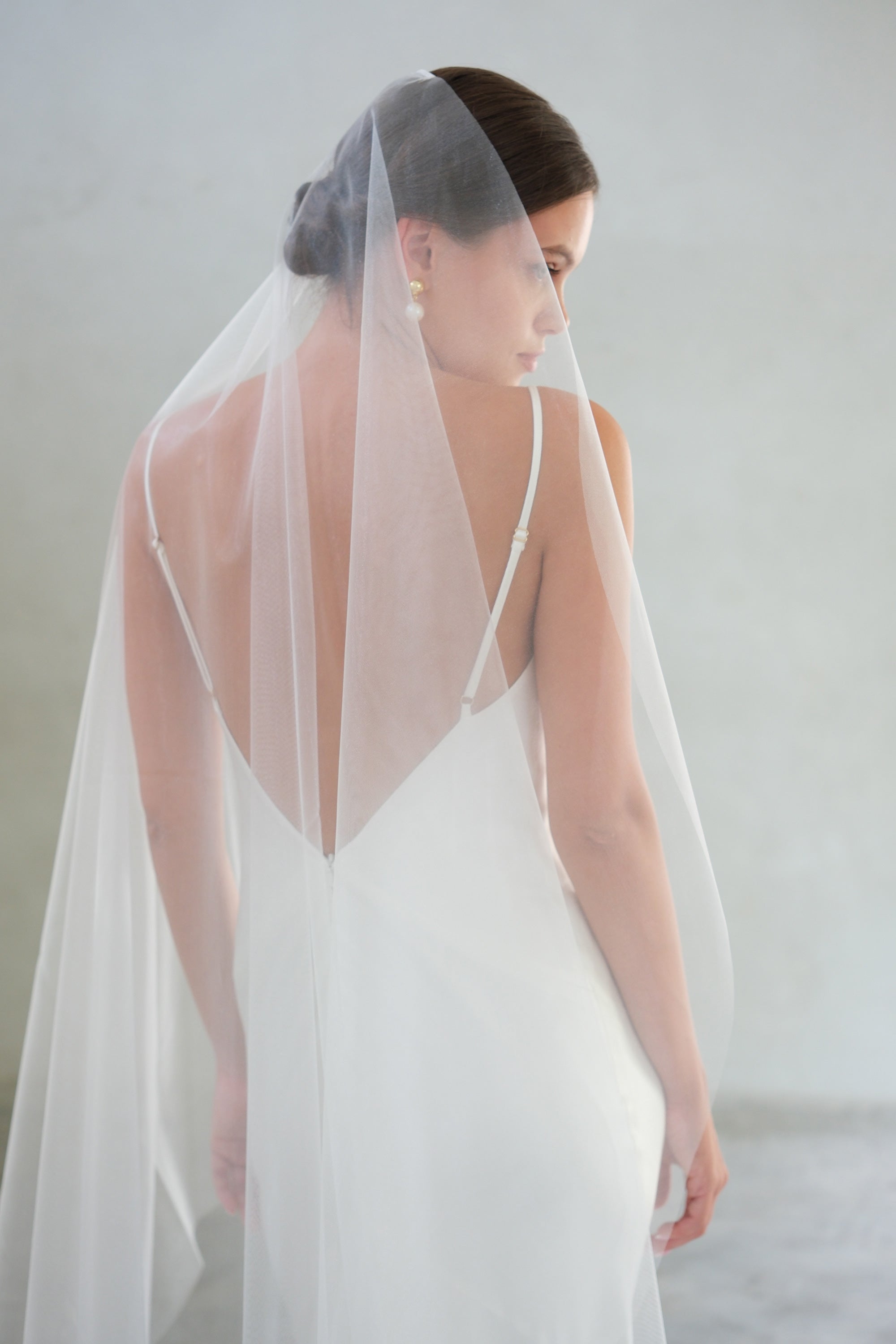 Back view/profile of bride wearing mantilla-style plain, shimmer tulle bridal veil
