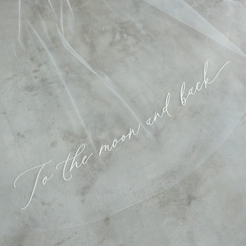 Romantic message embroidered in script font onto train of bridal veil by Madame Tulle