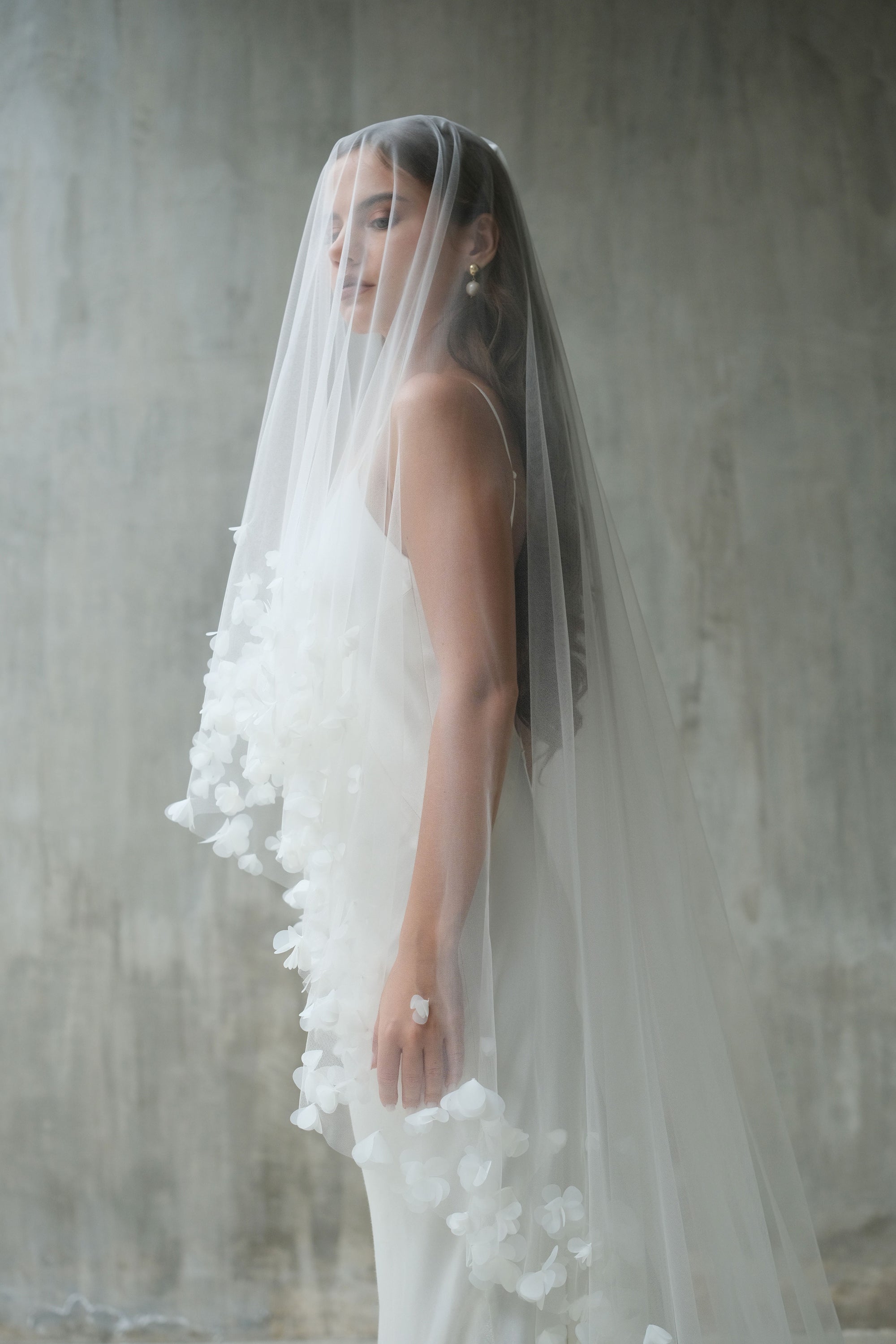 Side shot of bride wearing long veil embellished with fabric flowers