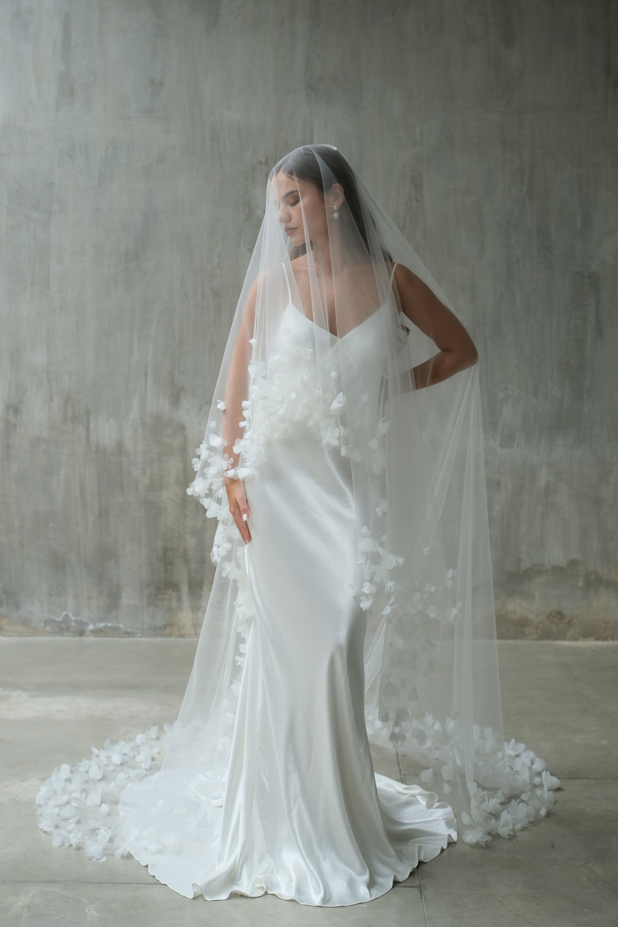 Full length front facing bride wearing lon veil with blusher and embellished with fabric flowers