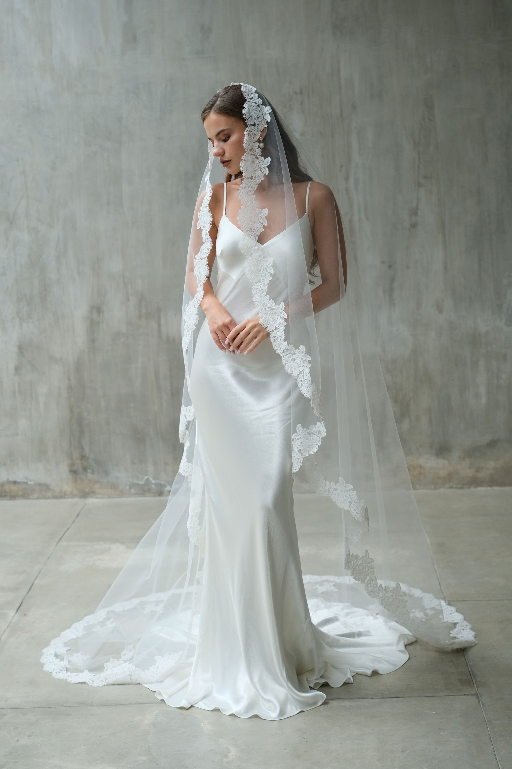 A bride wearing one-tier lace edge long wedding veil