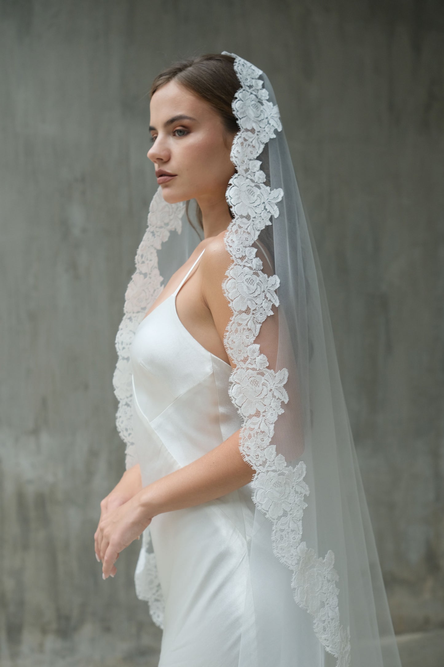 Side view of bride wearing one-tier mantilla lace edged veil