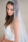 Model wears a pearl wedding veil, one tier veil with pearls.