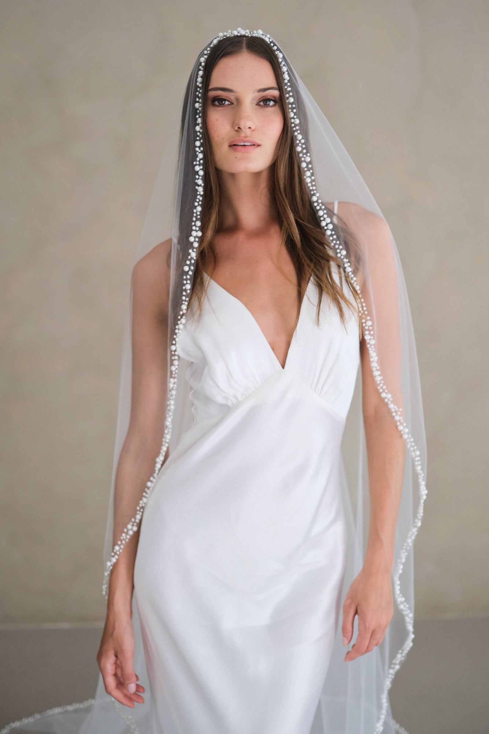 Model wears a pearl wedding veil, one tier veil with pearls.