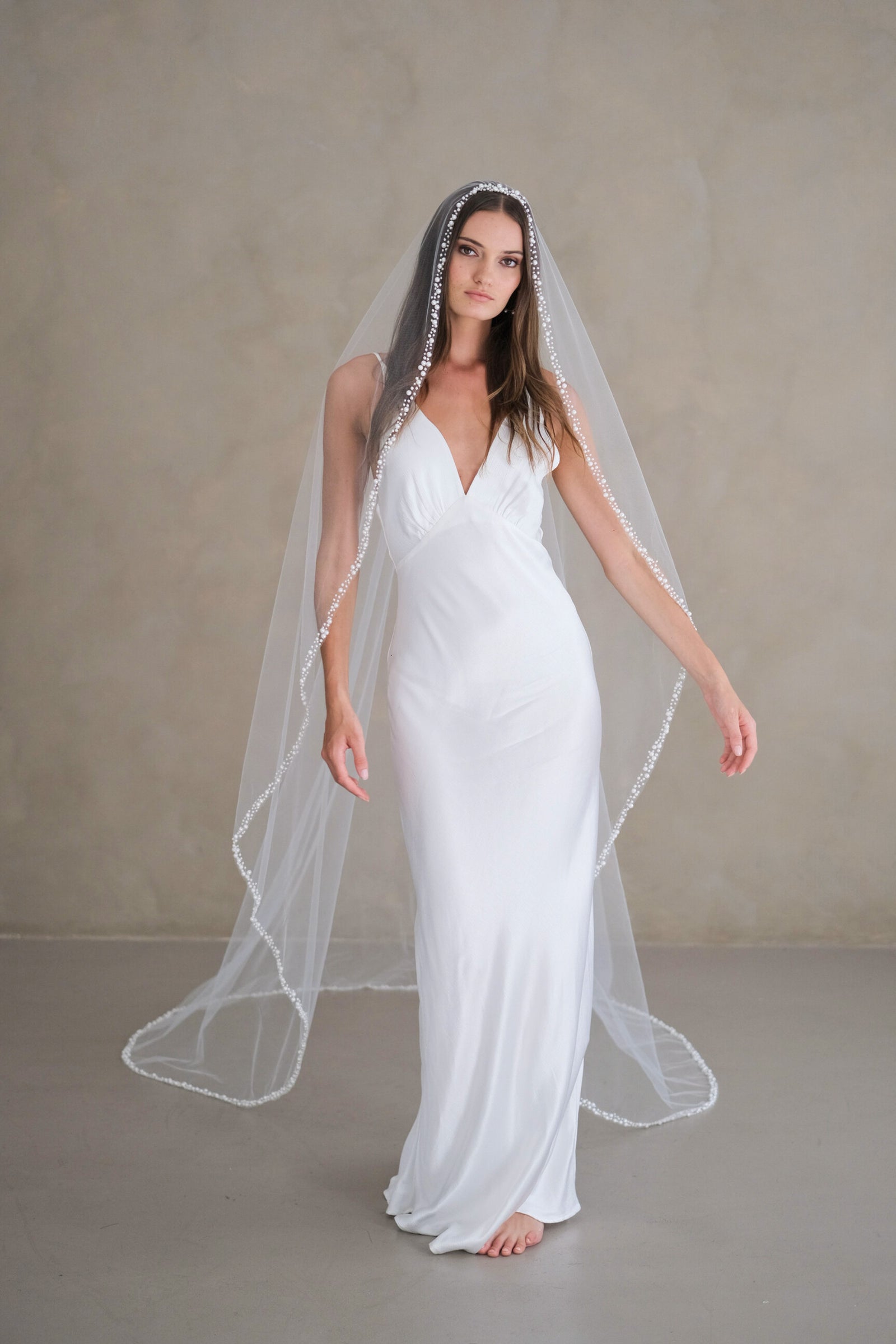 Model wears a pearl wedding veil, one tier veil with pearls.