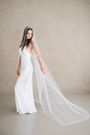 Model wears a pearl wedding veil, one tier veil with pearls.