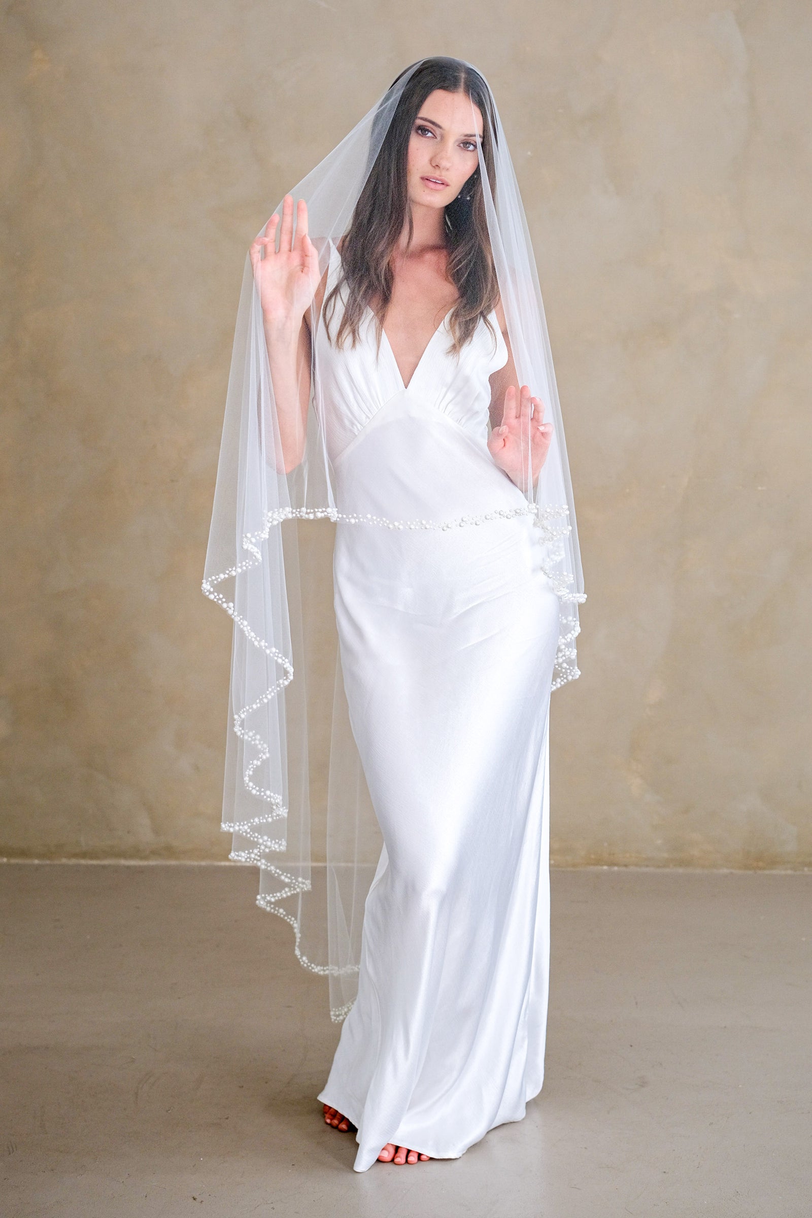 Model wears a pearl wedding veil, drop veil with pearls.