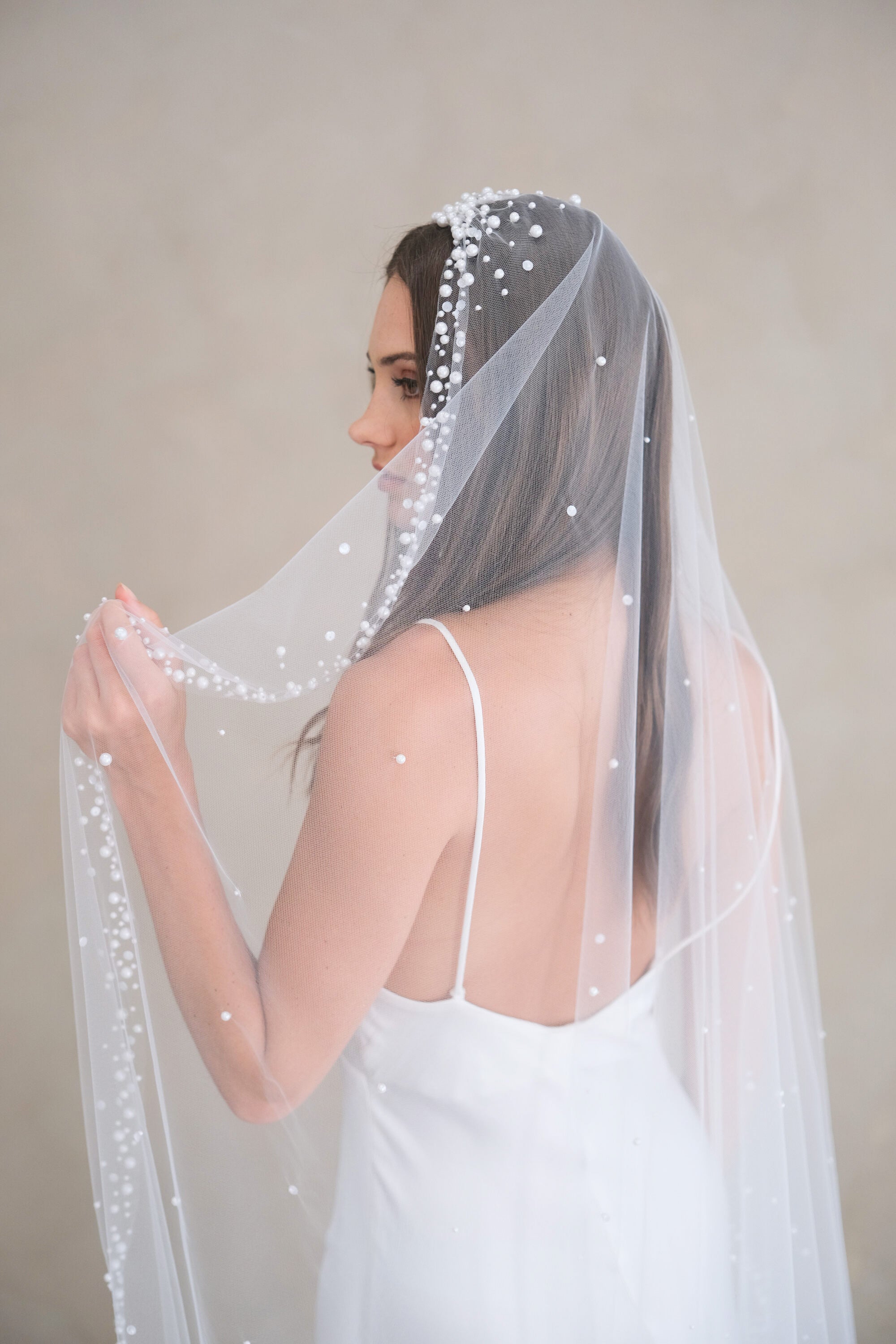 Model wears a pearls and sequins wedding veil, one tier veil