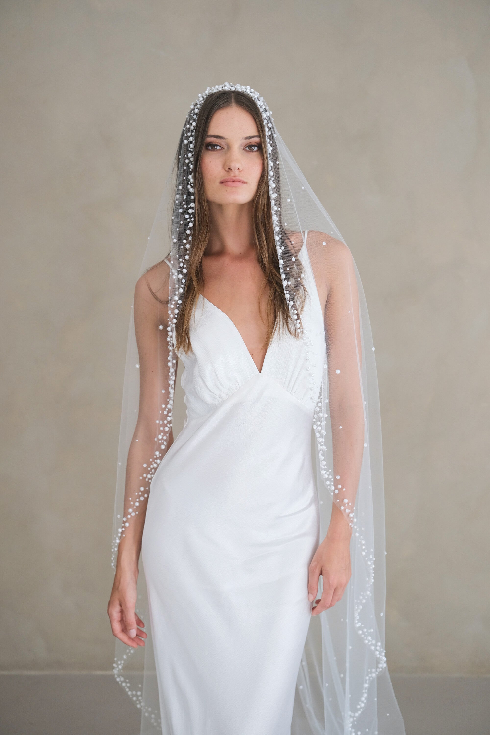 Model wears a pearls and sequins wedding veil, one tier veil