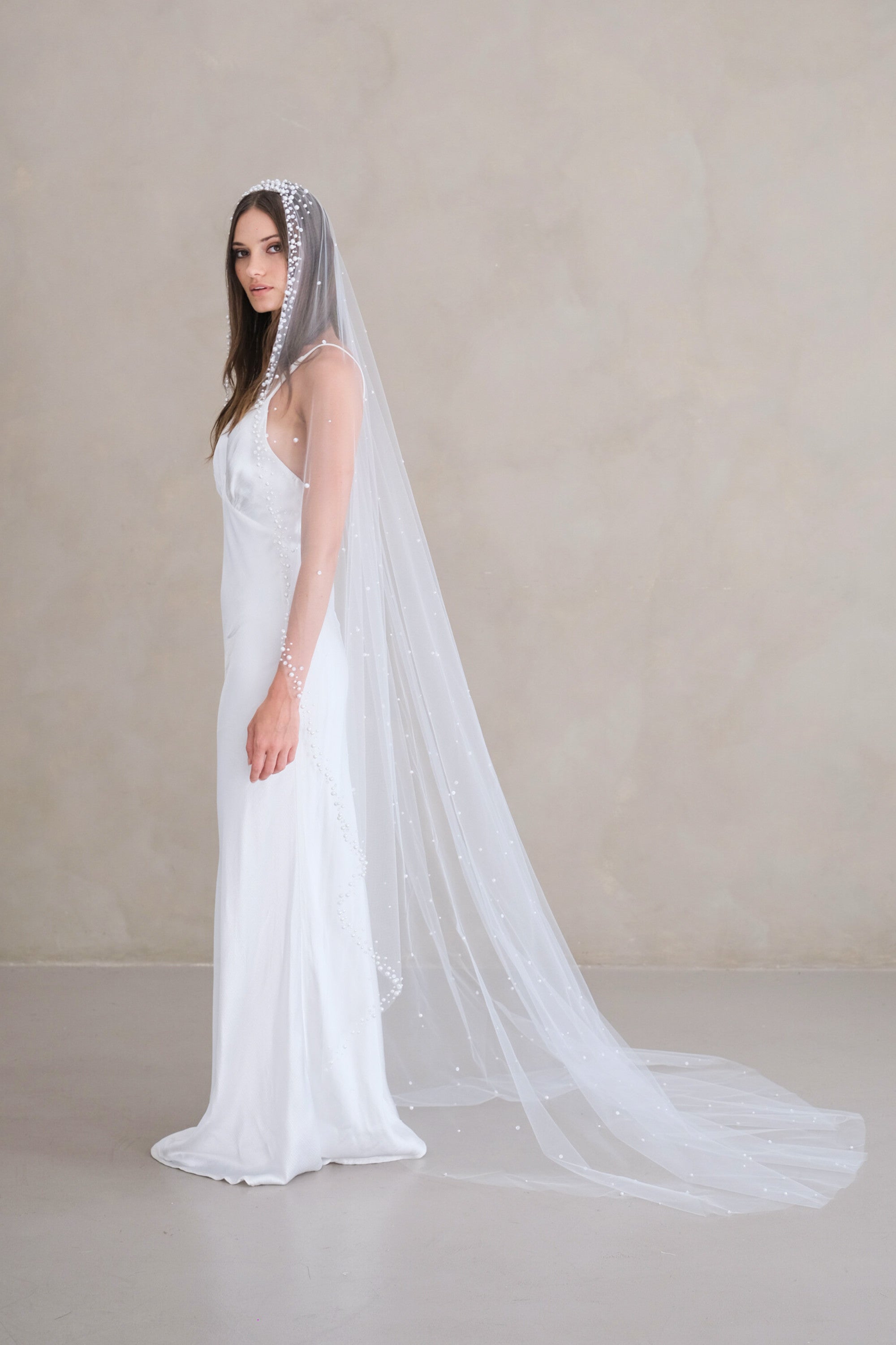 Model wears a pearls and sequins wedding veil, one tier veil