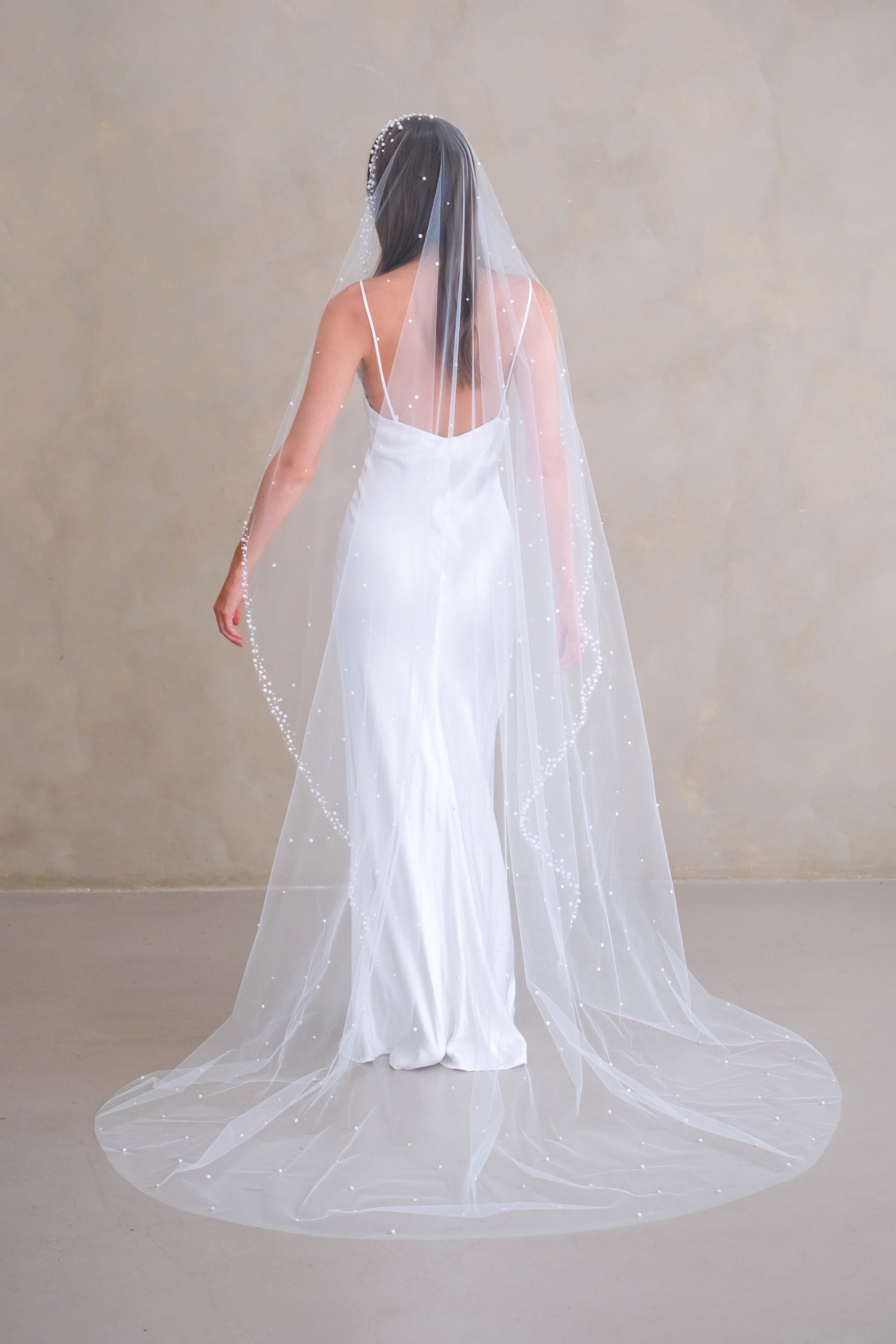 Model wears a pearls and sequins wedding veil, one tier veil