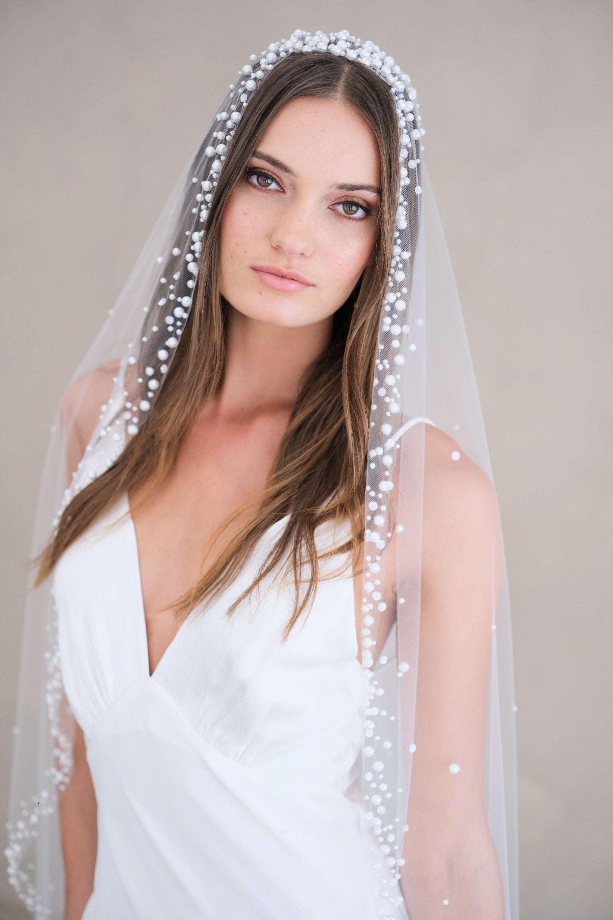 Model wears a pearls and sequins wedding veil, one tier veil