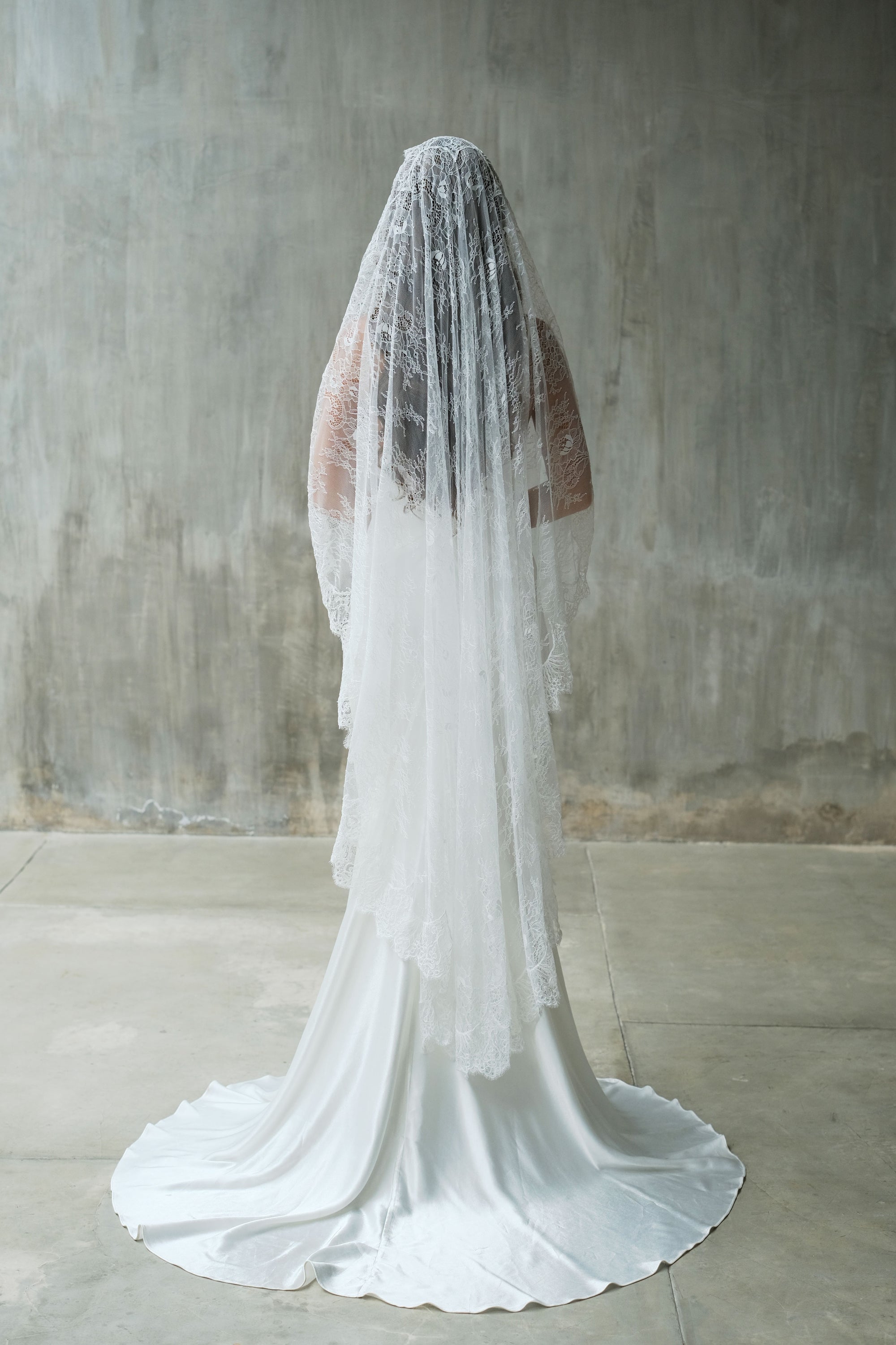 Full length back view of bride wearing waltz length full lace mantilla wedding veil