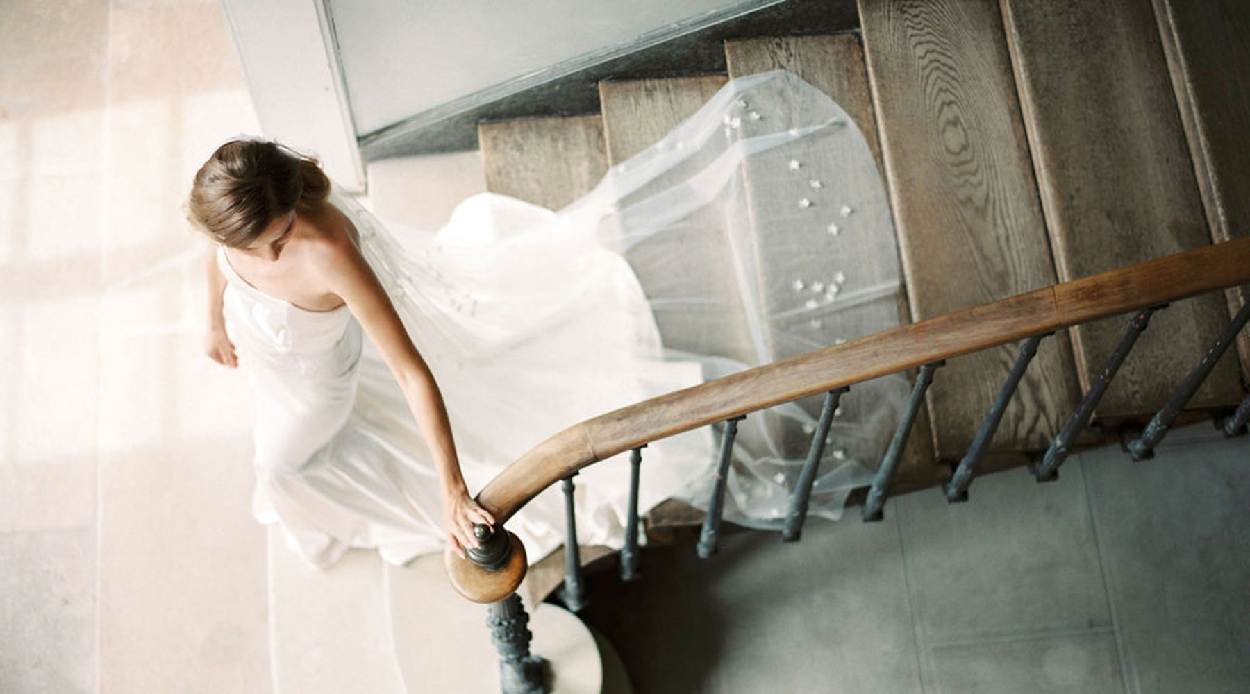 A bride walking down the stairs wearing a long wedding veil by Madame Tulle bridal Sydney