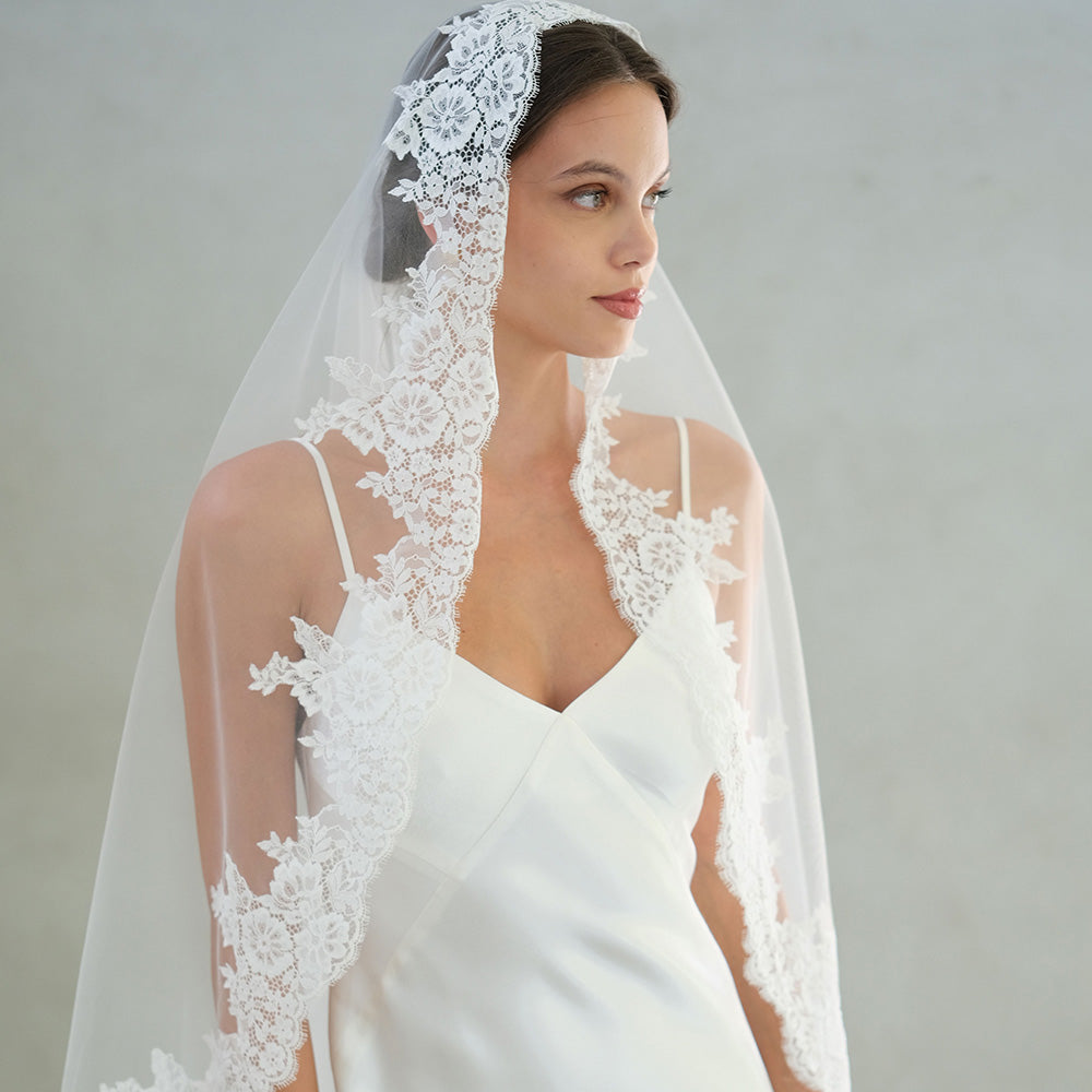 Bride models lace trimmed mantilla veil
