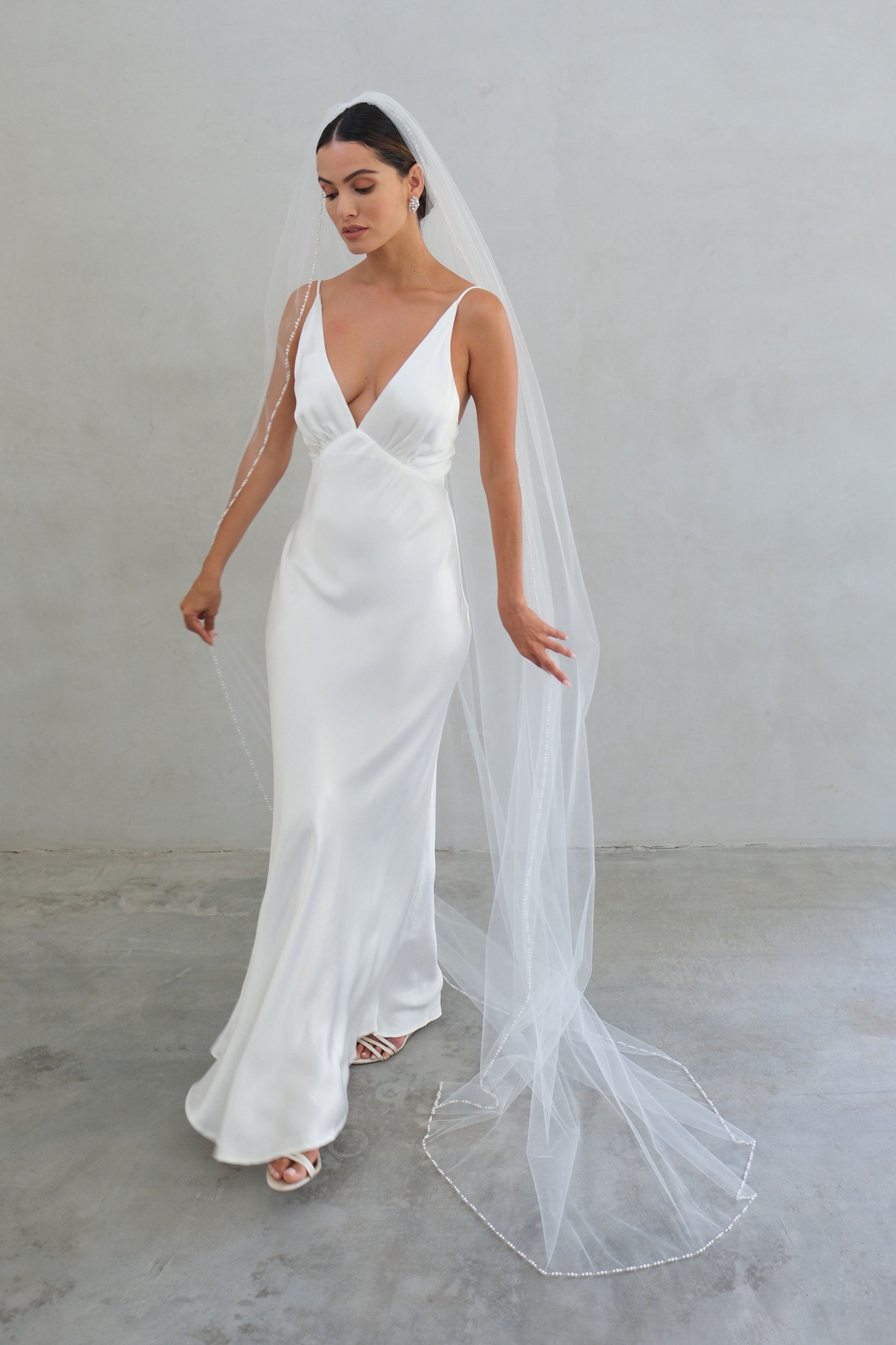 model wears a one-tier wedding veil, veil with pearls on the edge