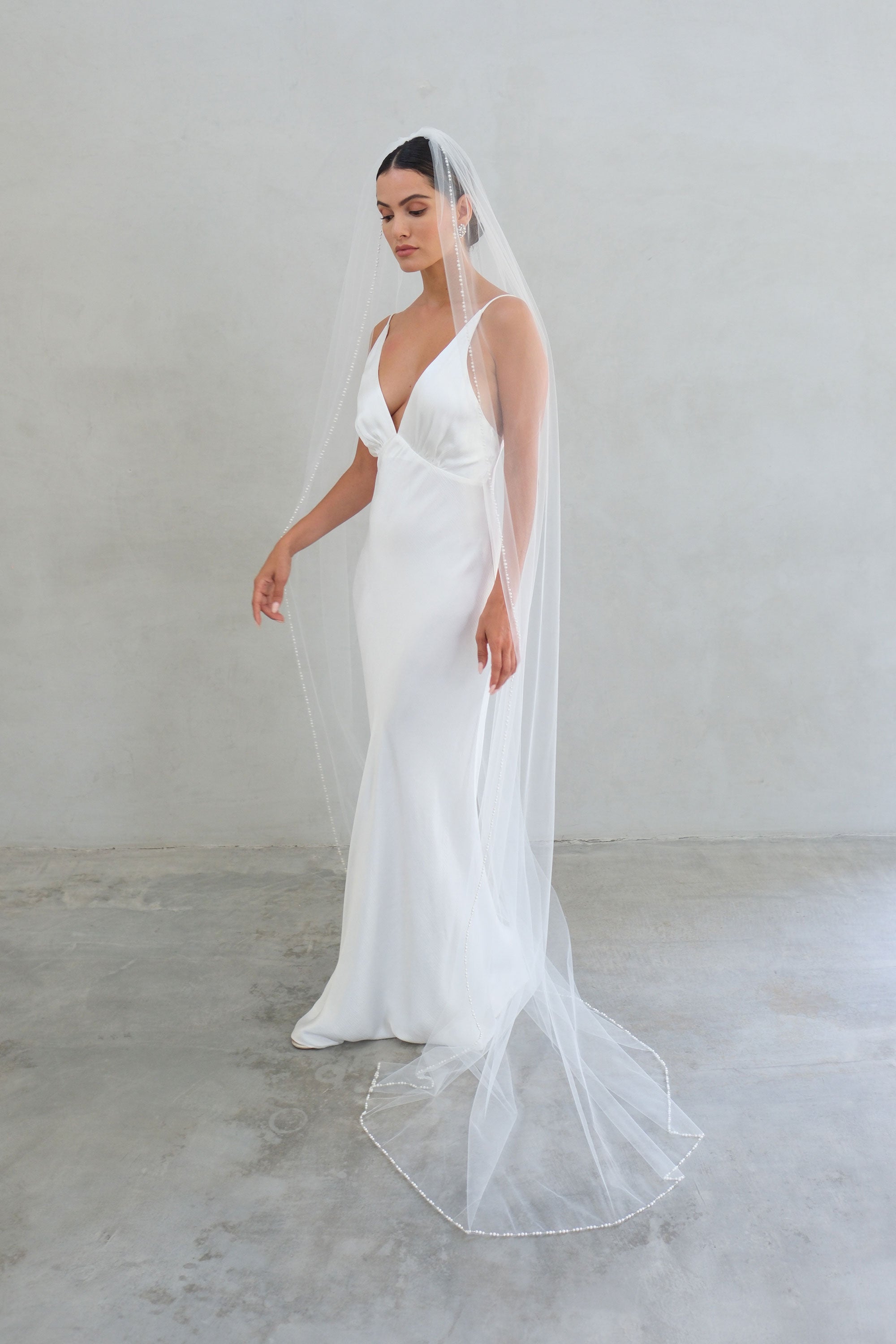 model wears a one-tier wedding veil, veil with pearls on the edge