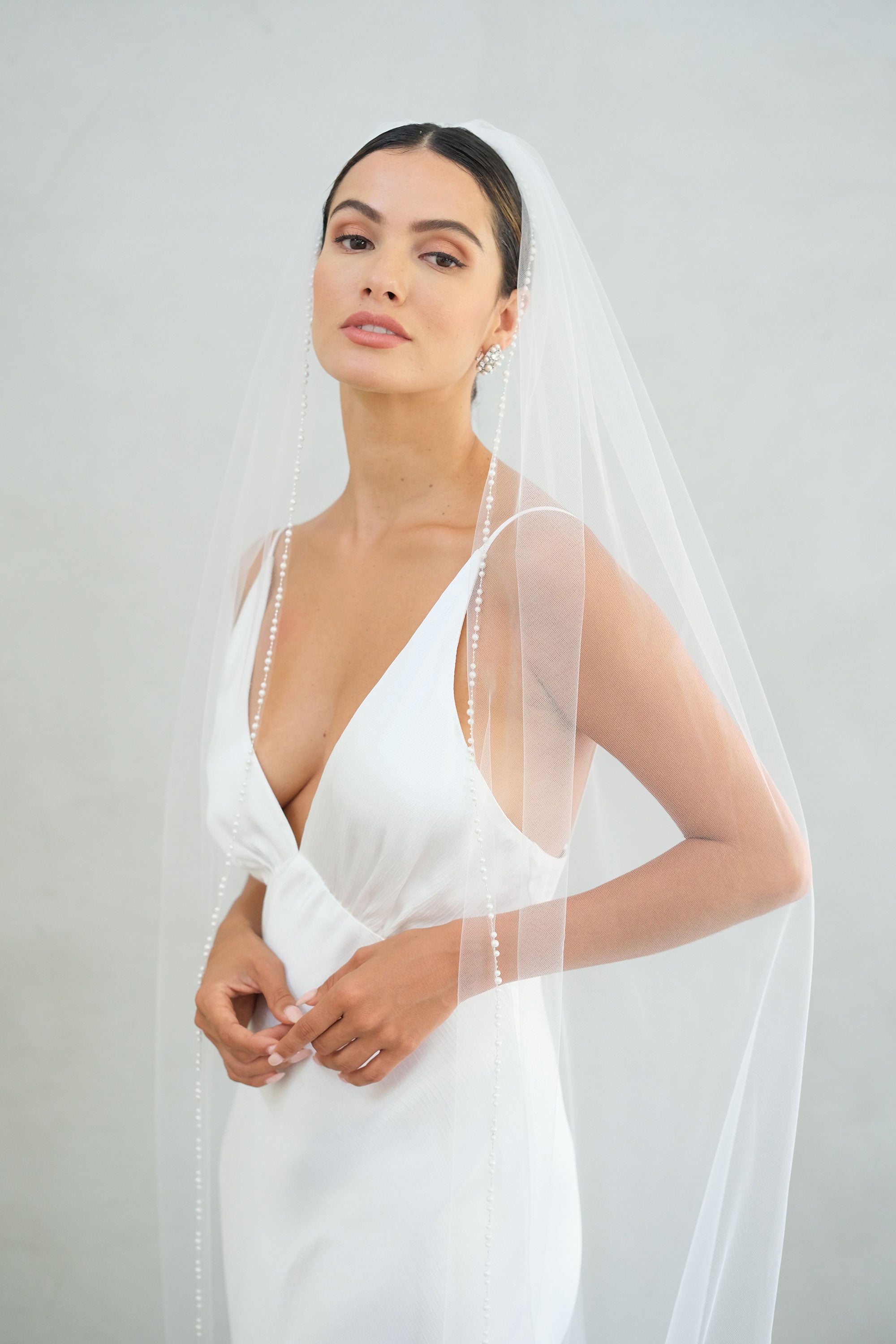 model wears a one-tier wedding veil, veil with pearls on the edge
