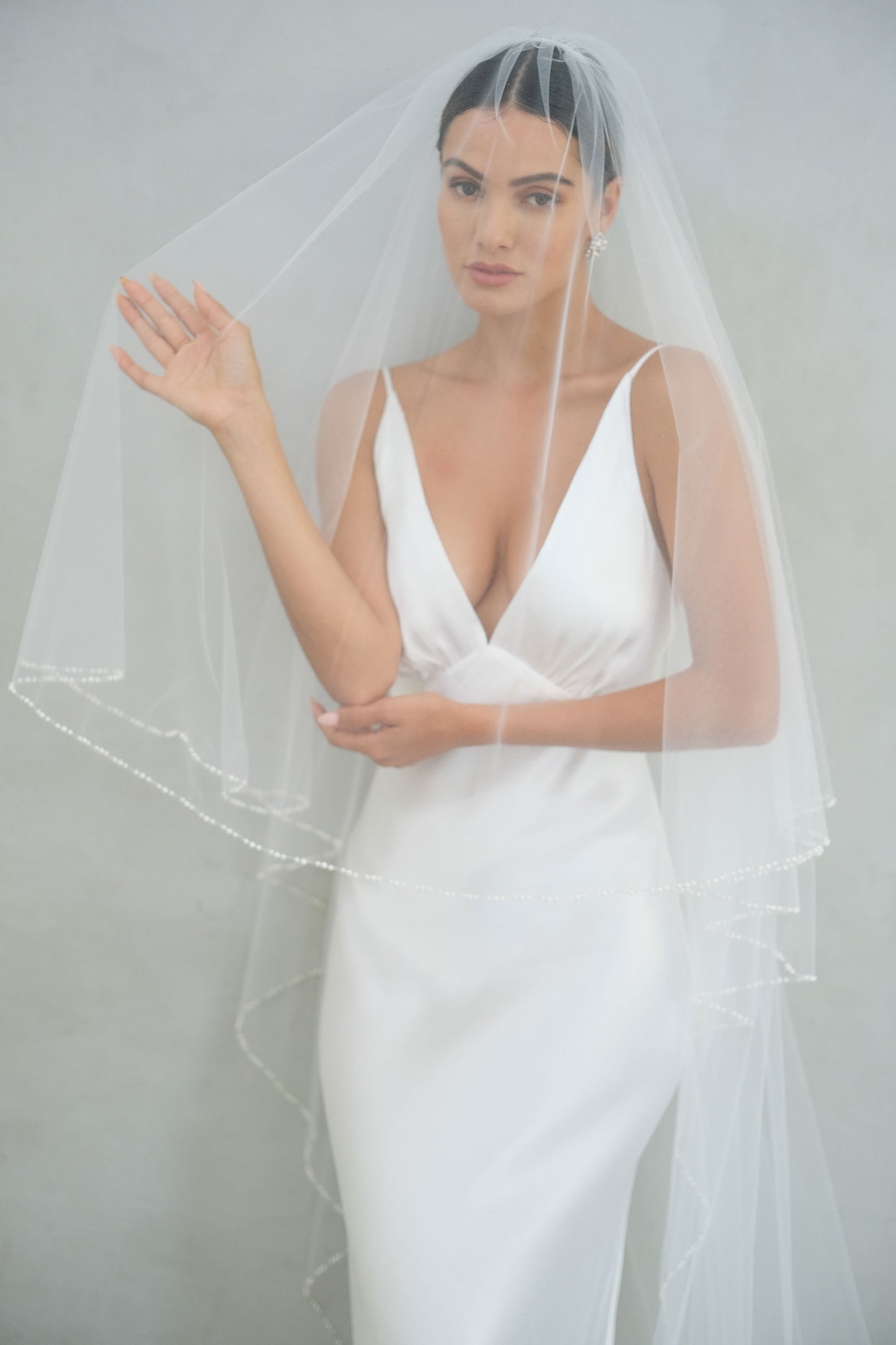 model wears a two-tier wedding veil, drop veil with pearls on the edge