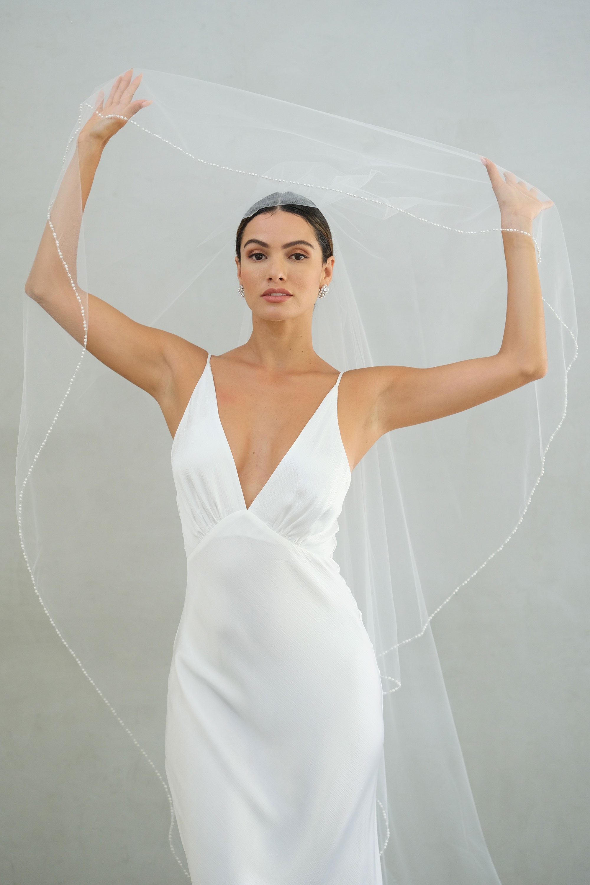 model wears a two-tier wedding veil, drop veil with pearls on the edge