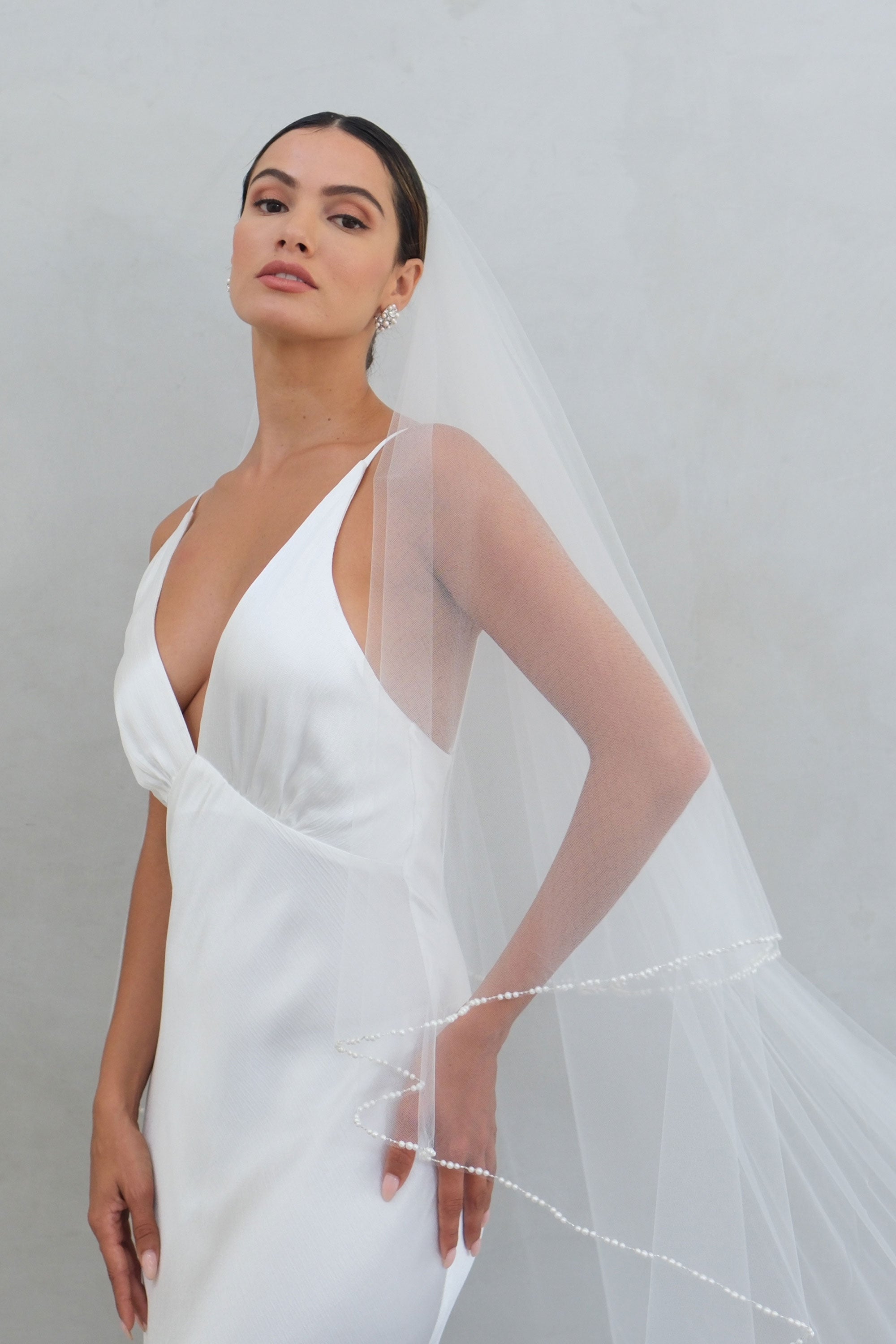 model wears a two-tier wedding veil, drop veil with pearls on the edge