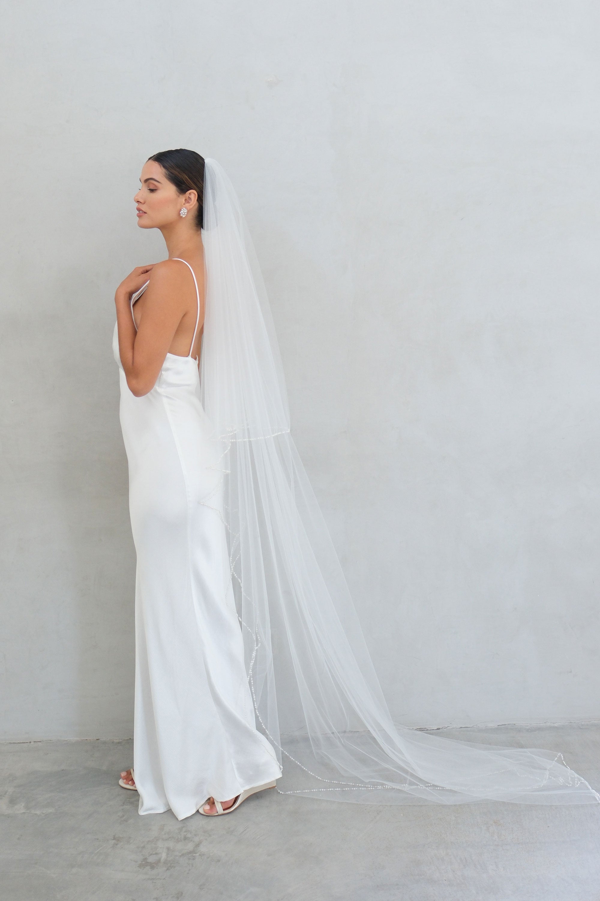 model wears a two-tier wedding veil, drop veil with pearls on the edge