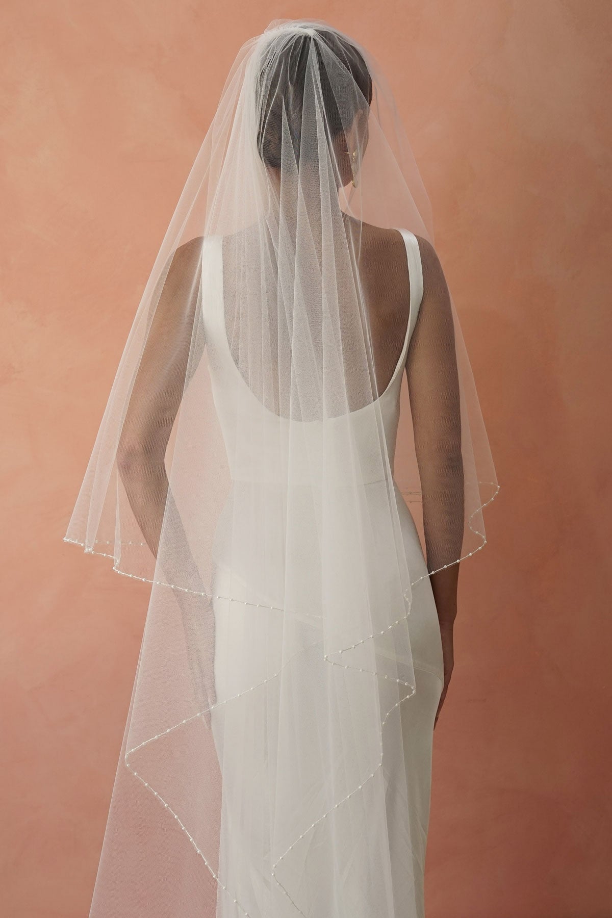 model wears two-tier pearl edge veil, drop veil with pearls on the edges