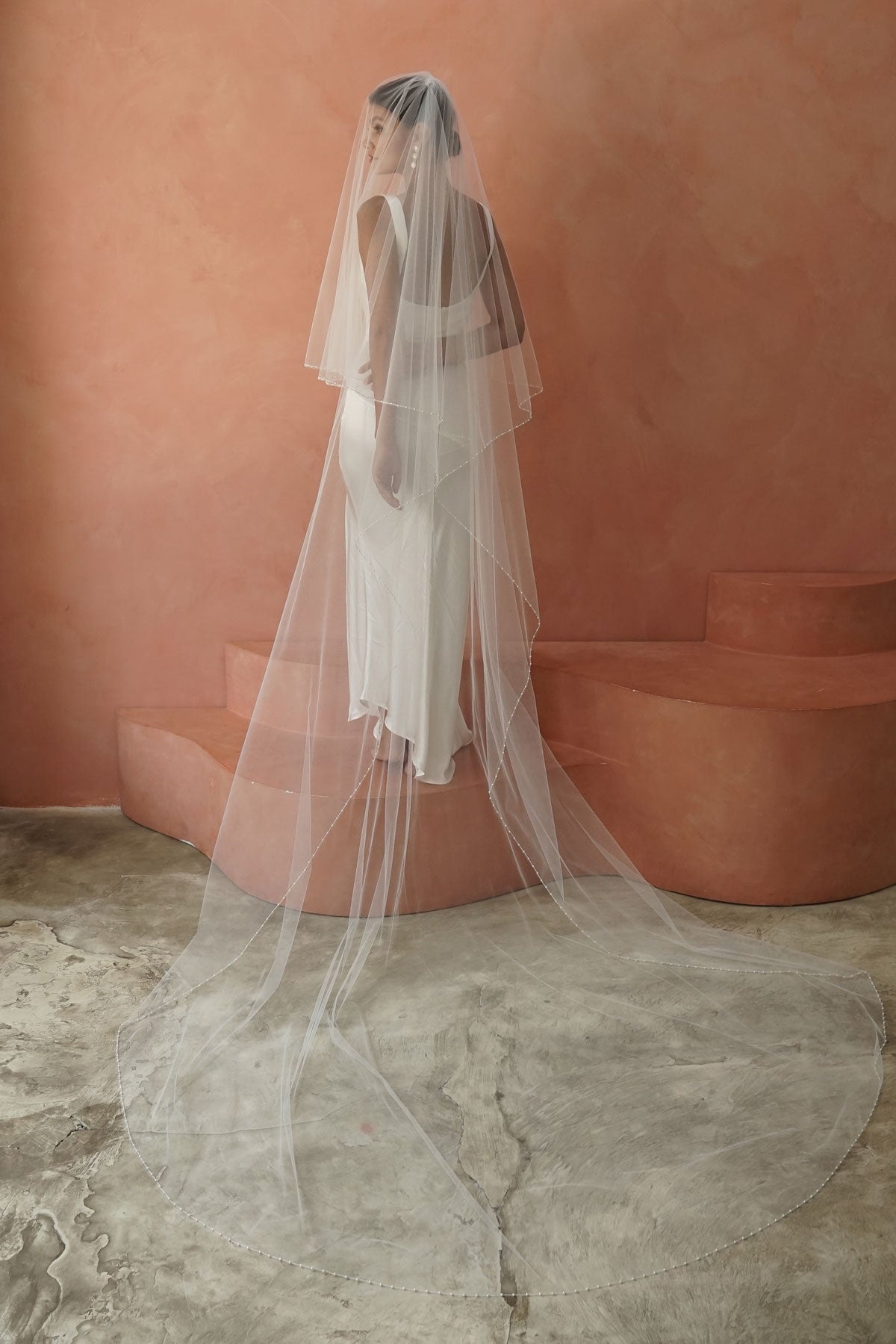 model wears two-tier pearl edge veil, drop veil with pearls on the edges