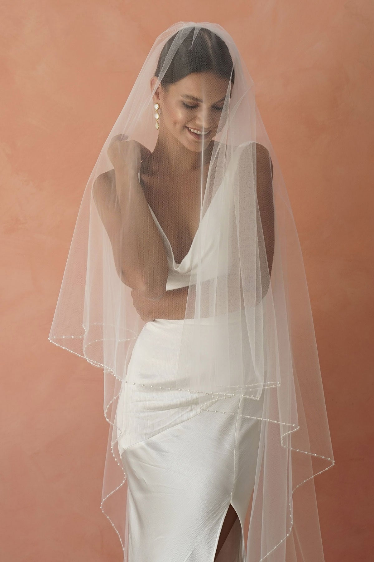 model wears two-tier pearl edge veil, drop veil with pearls on the edges