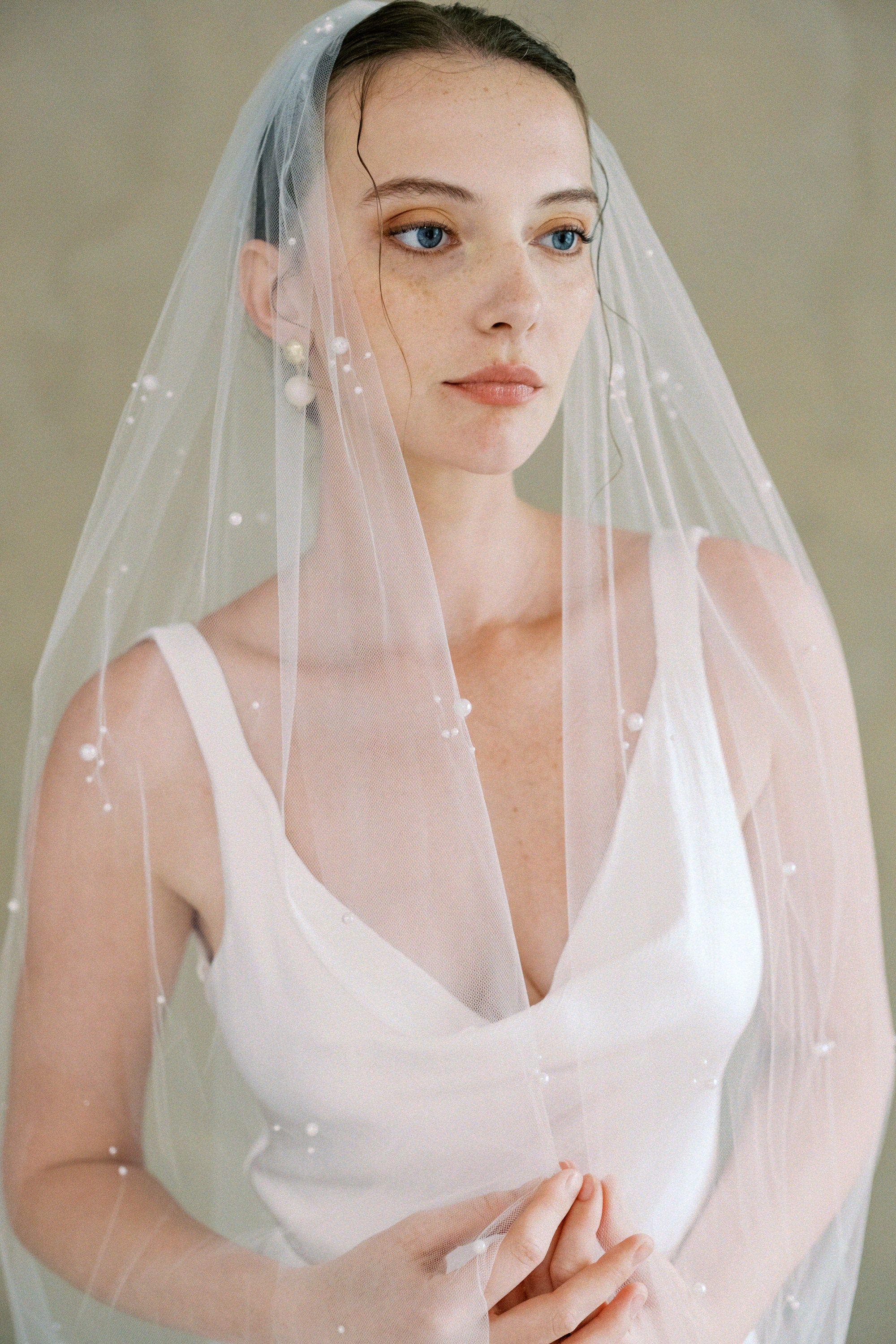 Model wears a one tier pearl wedding veil made by Madame Tulle bridal