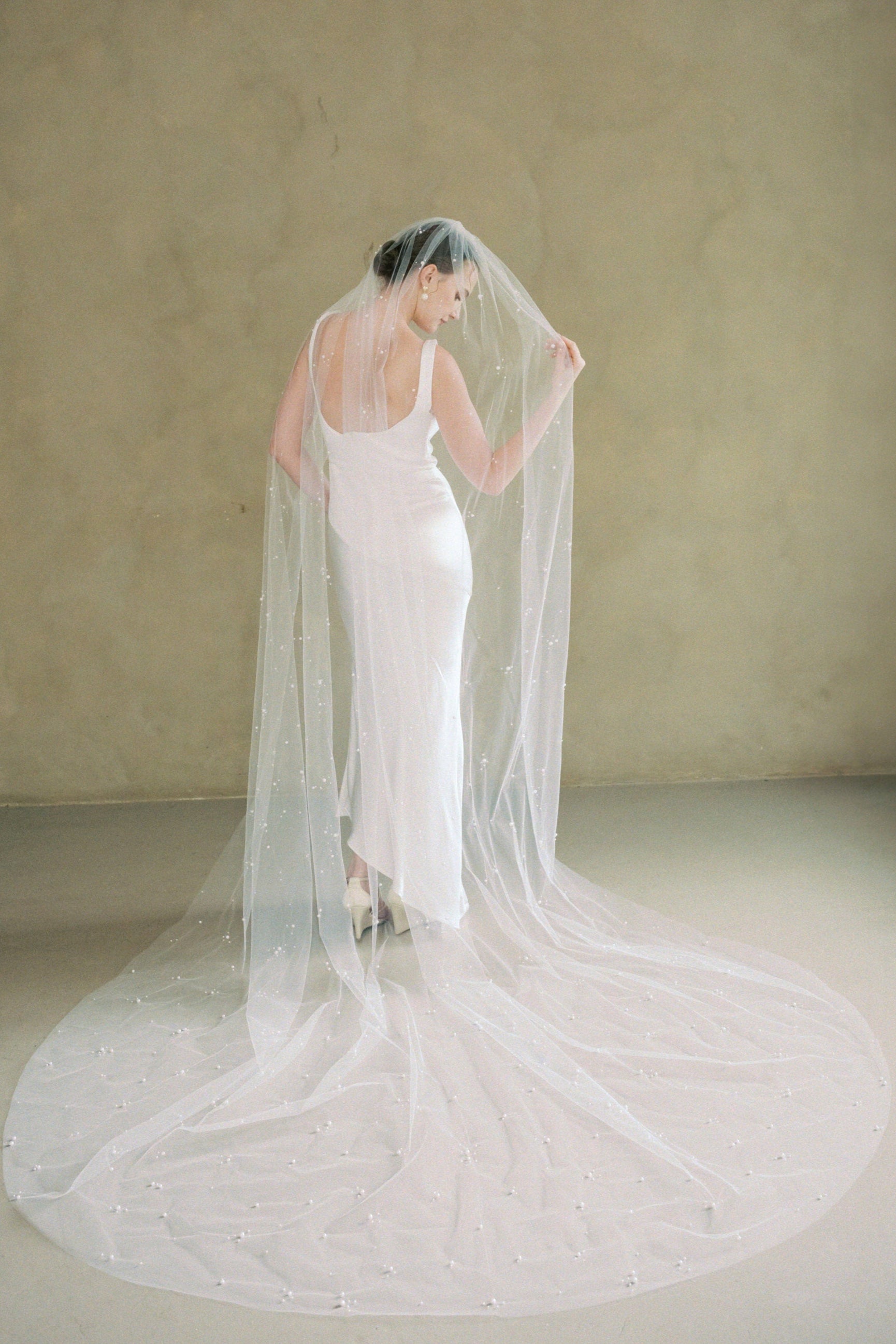 Model wears a one tier pearl wedding veil made by Madame Tulle bridal