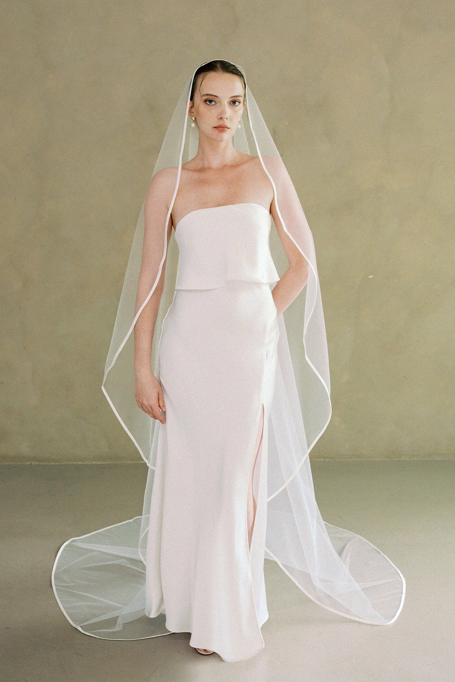 Model wears one-tier satin edge wedding veil shown at full length