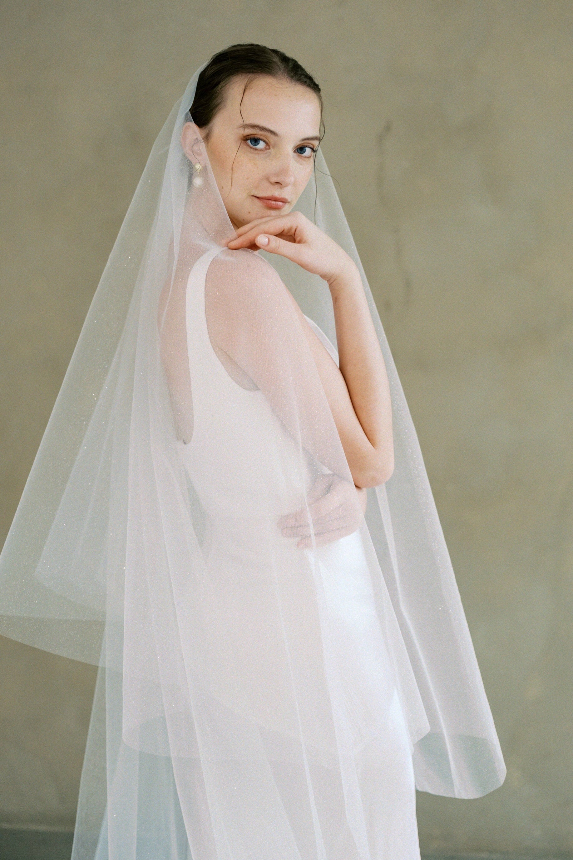 model wears a drop veil glitter wedding veil