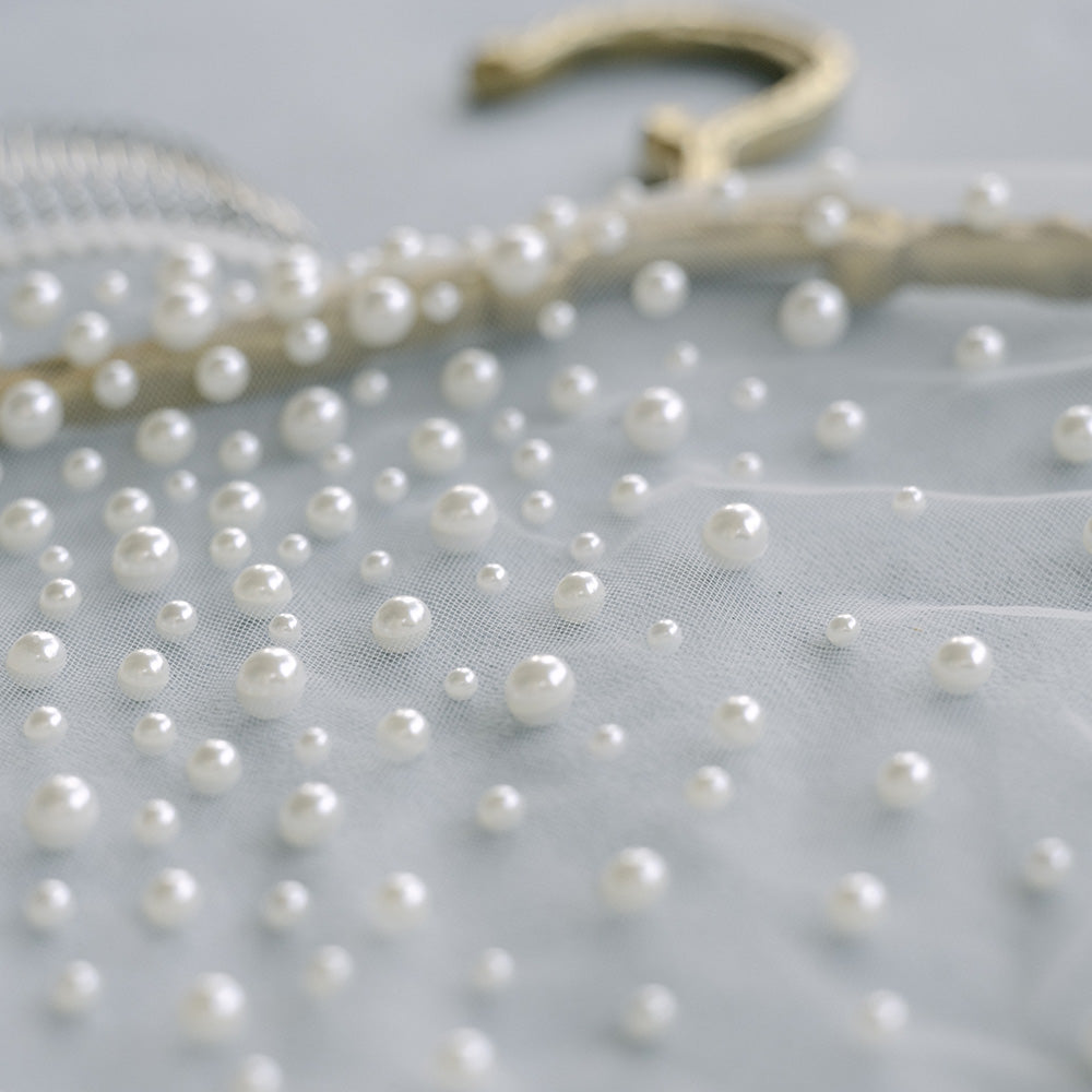 Close up of pearls of varying sizes scattered on tulle of bridal veil by Madame Tulle Sydney
